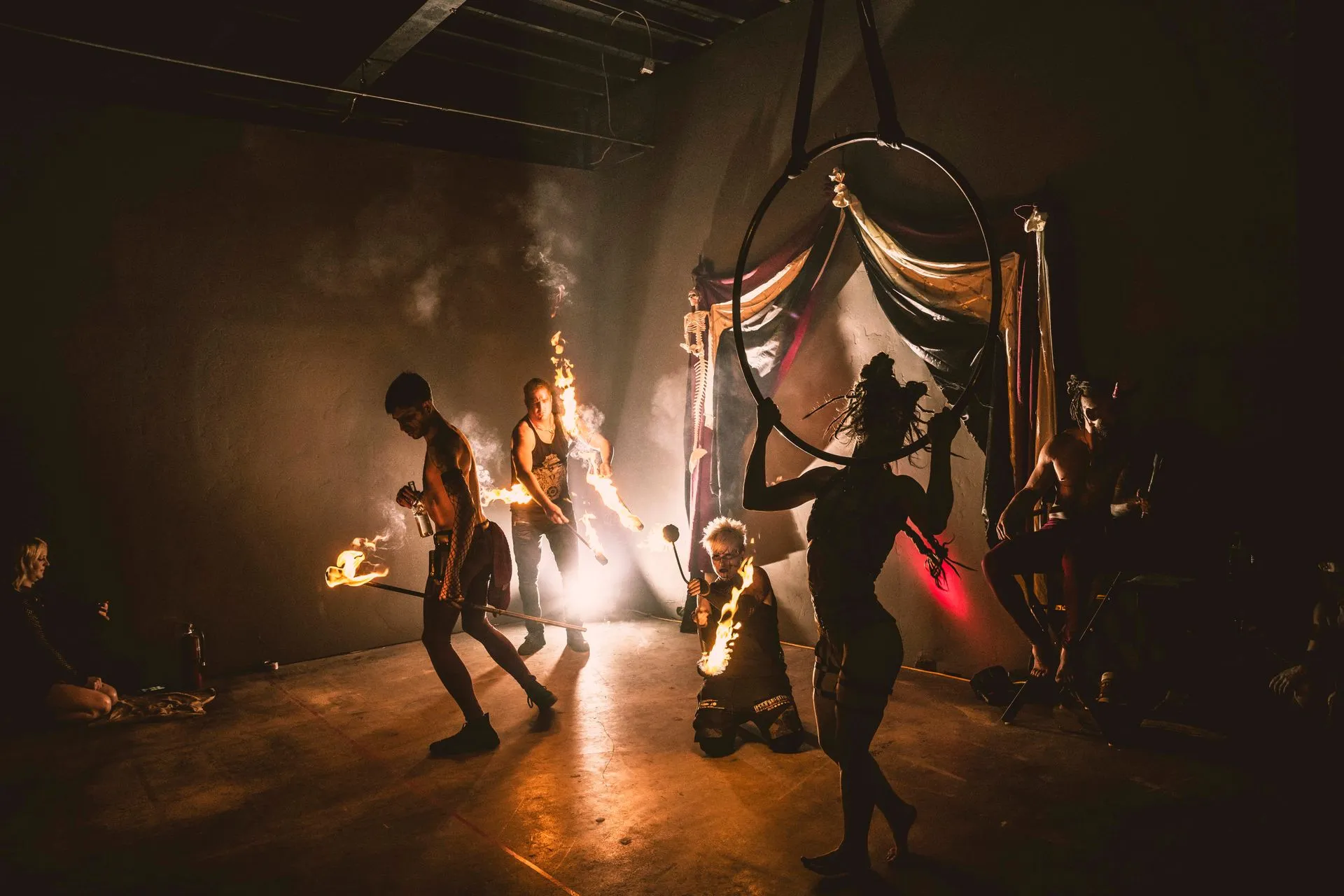 A group of people are dancing on a stage in a dark room.