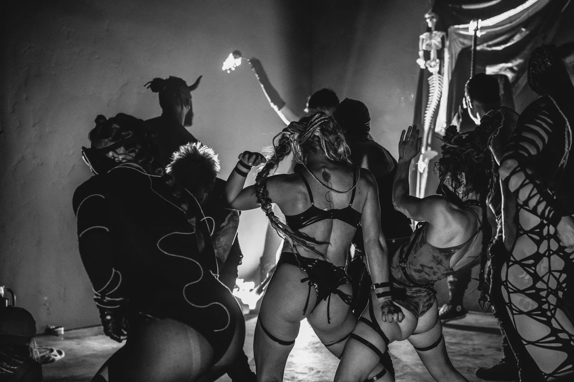 A group of women in lingerie are dancing in a dark room.