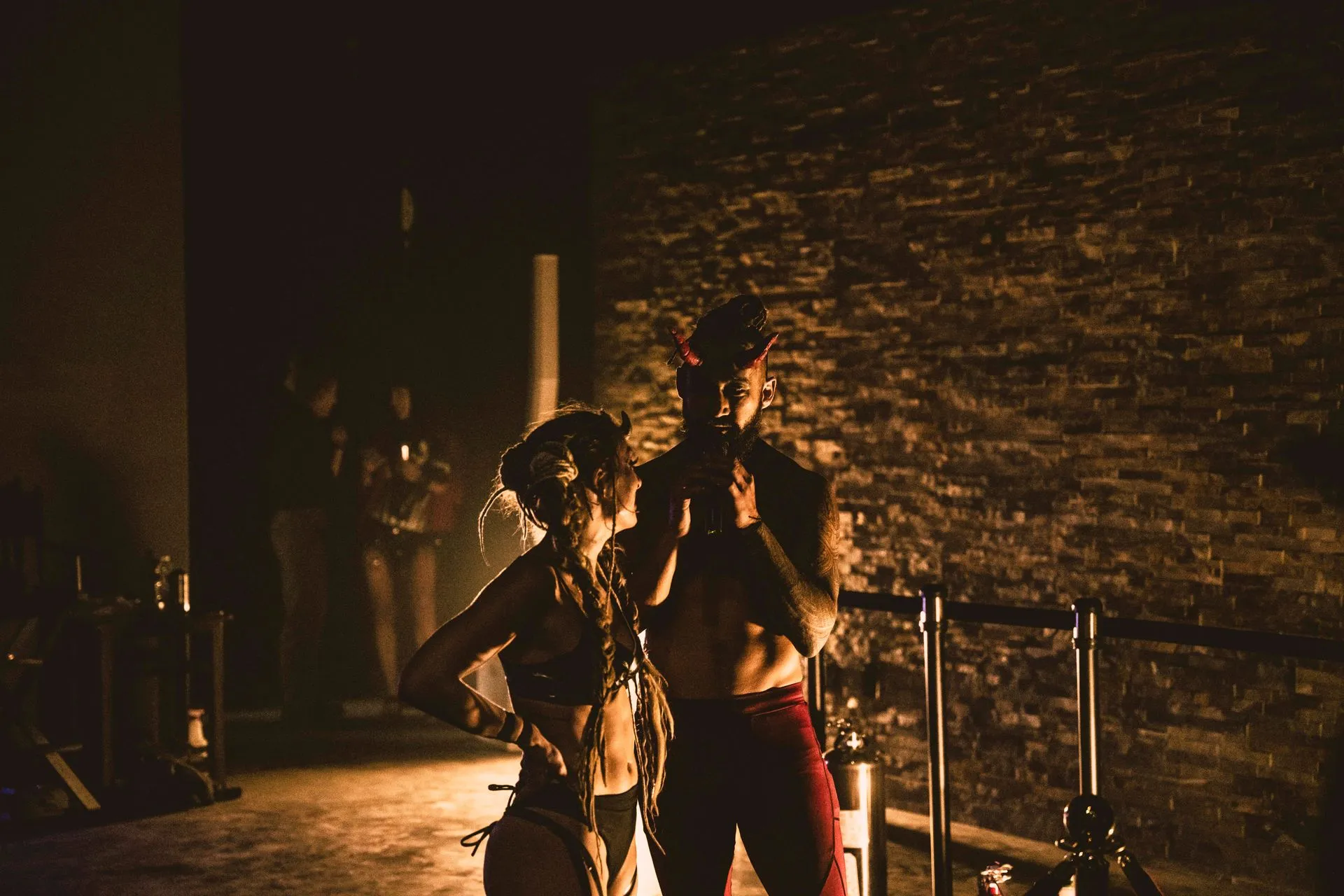 A man and a woman are standing next to each other in a dark room.