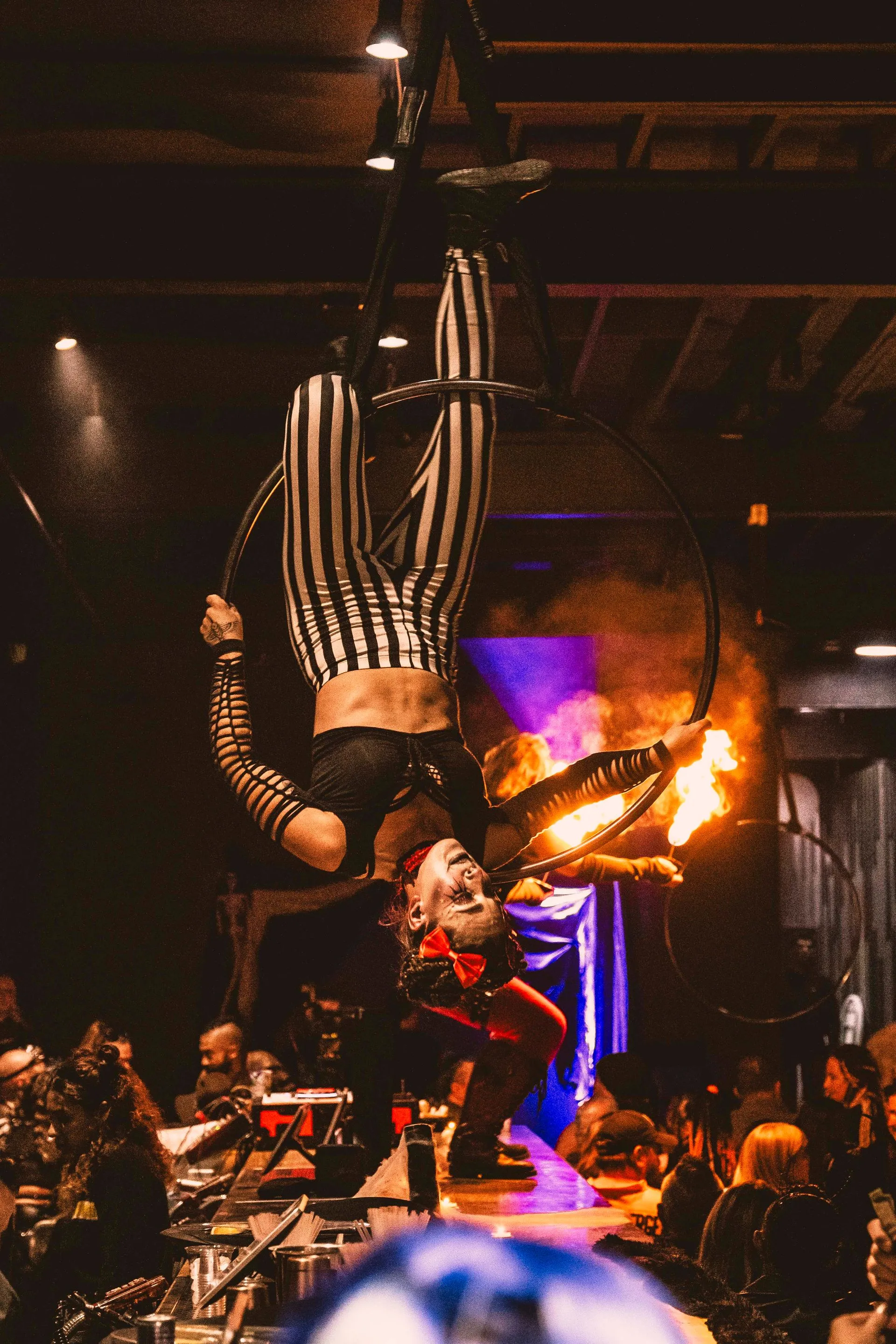 A woman is performing aerial acrobatics in front of a crowd.