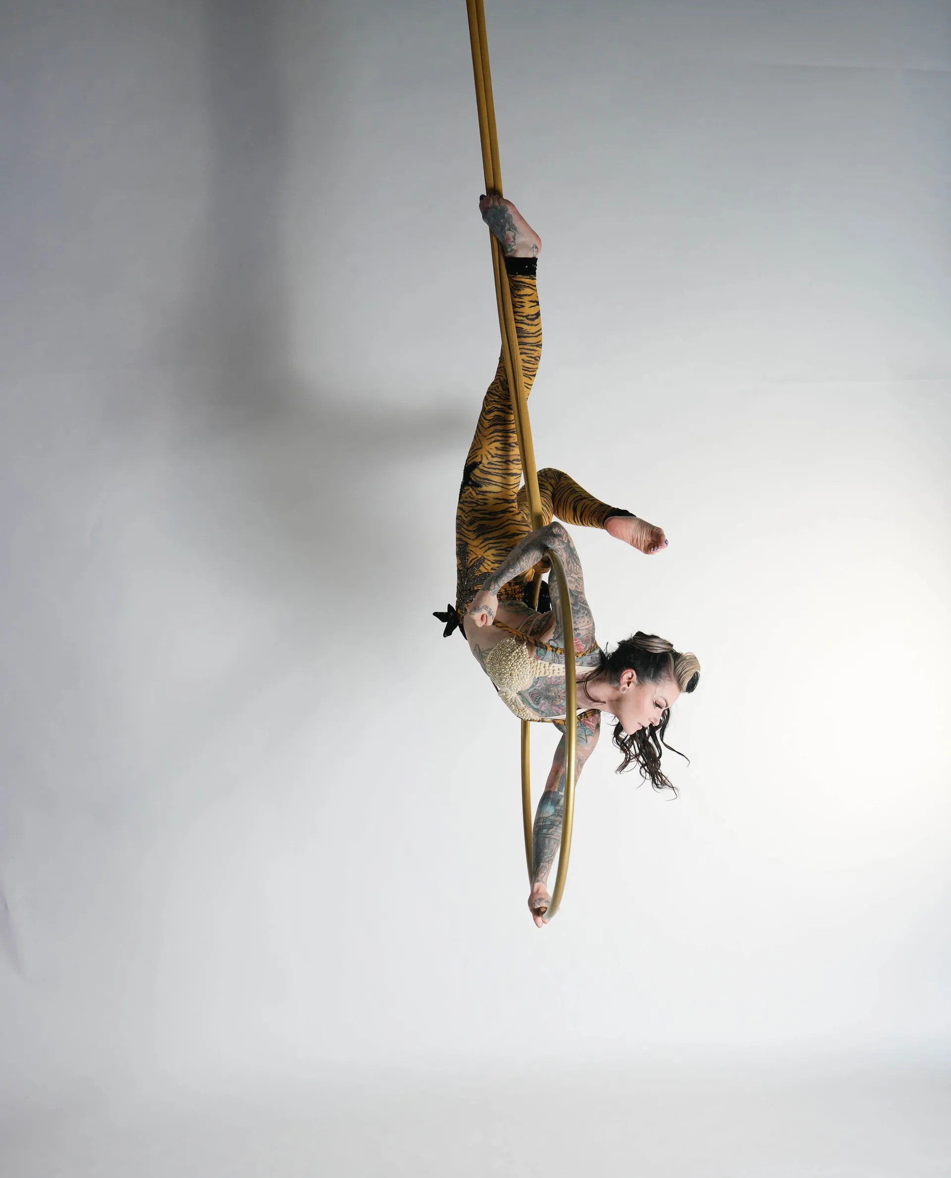 A woman is performing aerial acrobatics on a rope