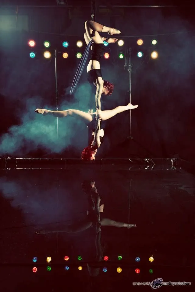 A couple of aerial dancers are performing on a stage.