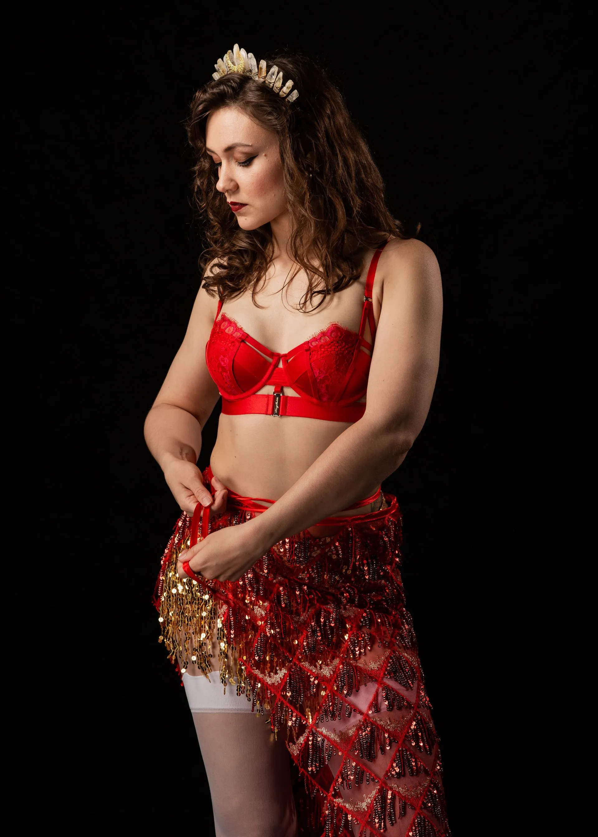 The woman is wearing a red bra and a red skirt.