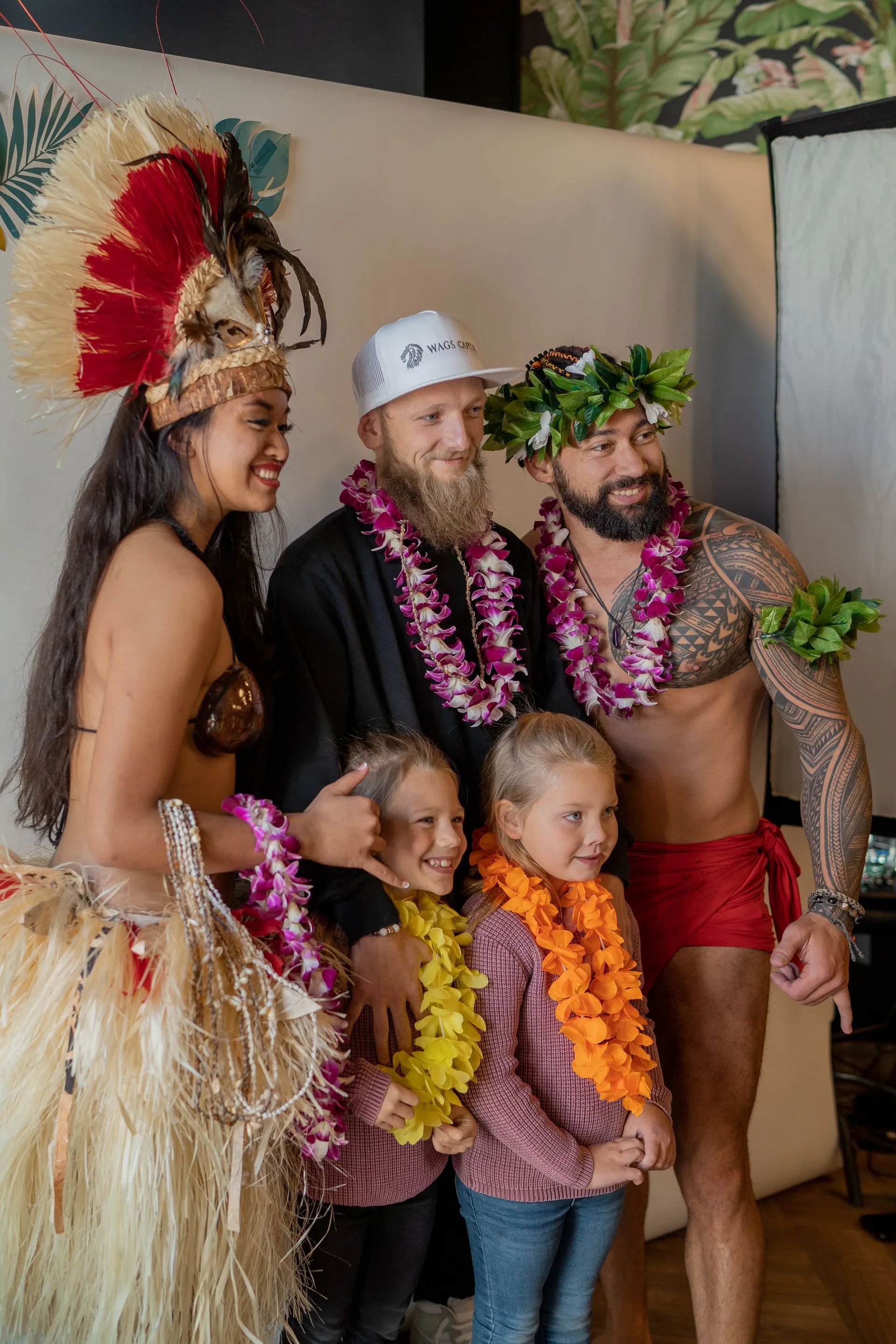 A group of people dressed in hawaiian costumes are posing for a picture.