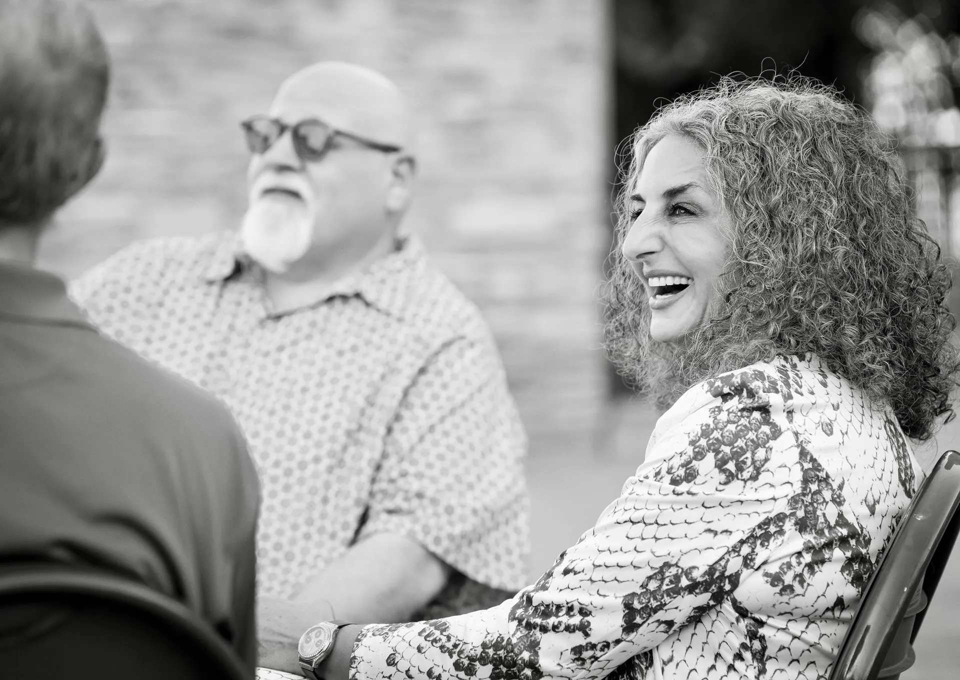 A black and white photo of a group of people sitting around a table.