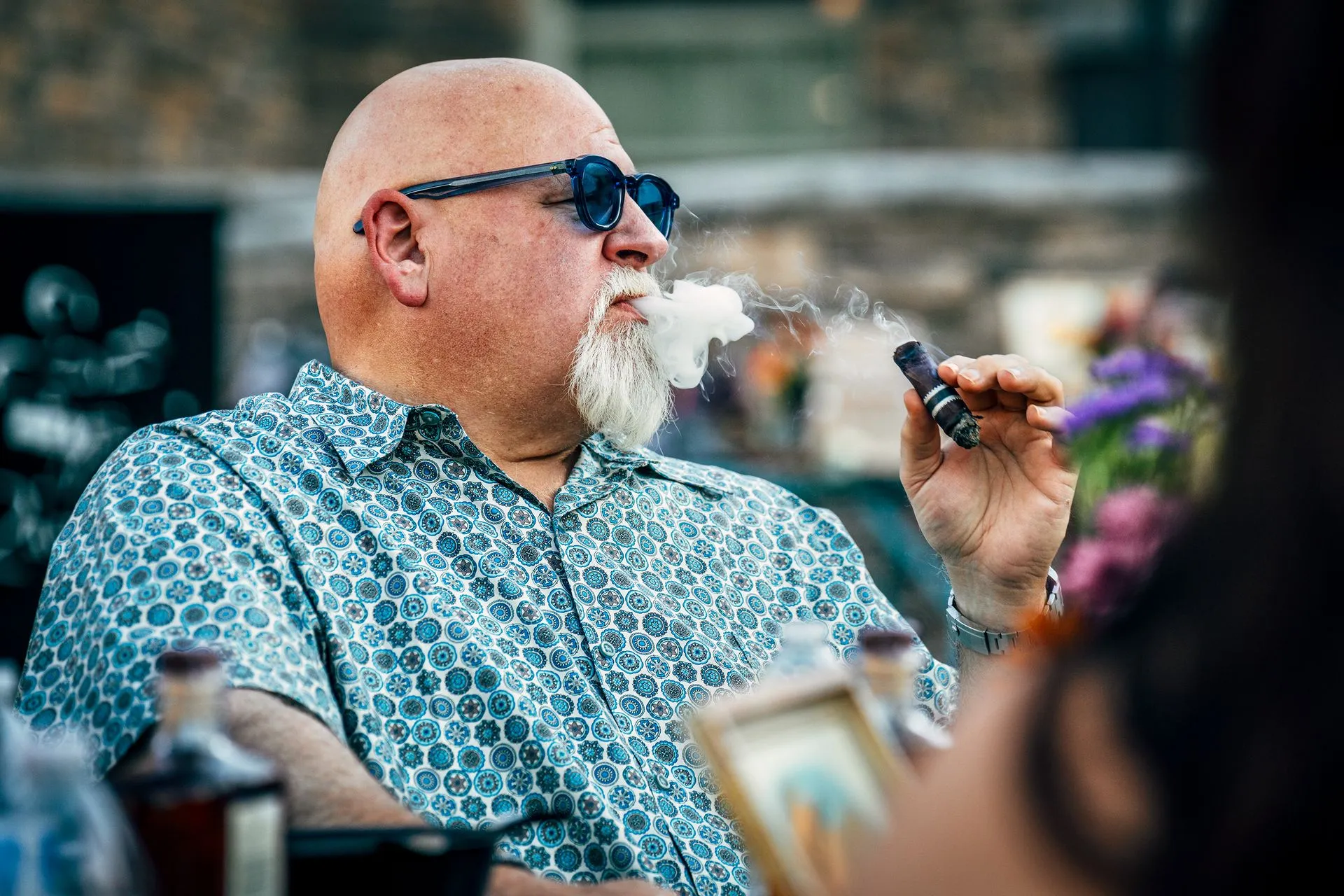 A prestigious looking man smoking a cigar. 