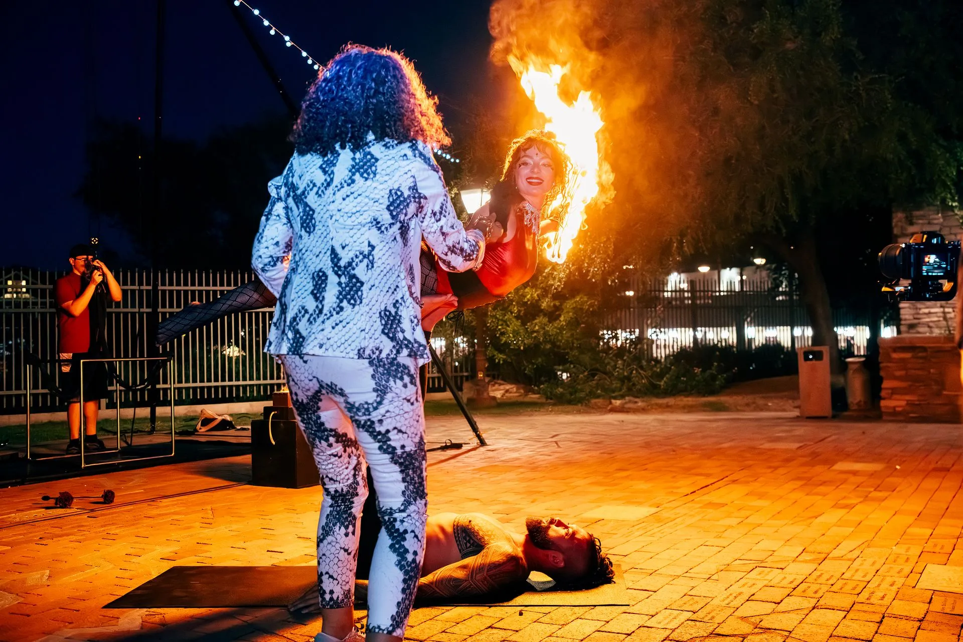 A woman is holding a child in her arms while a man is laying on the ground.