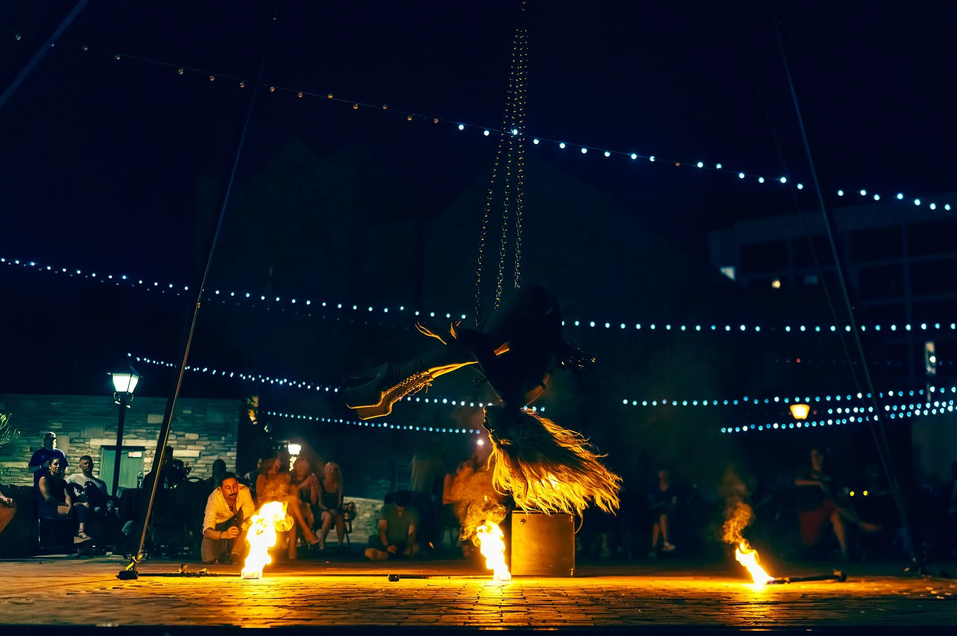 A person is standing on a stage with flames coming out of it.