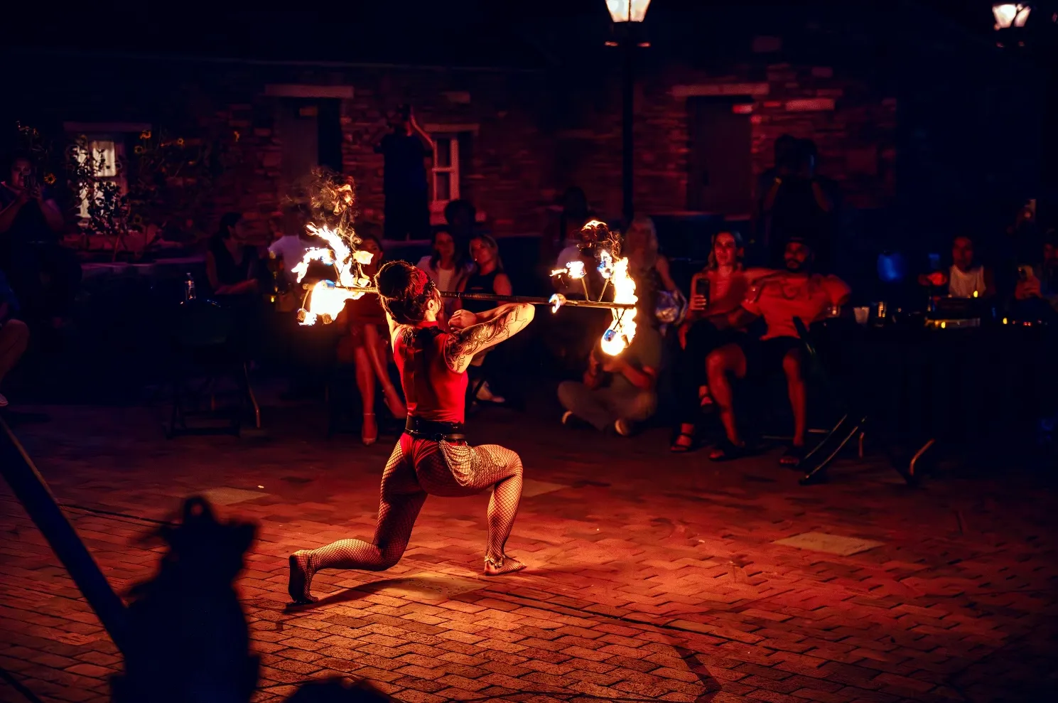 A woman is performing a fire show in front of a crowd of people.