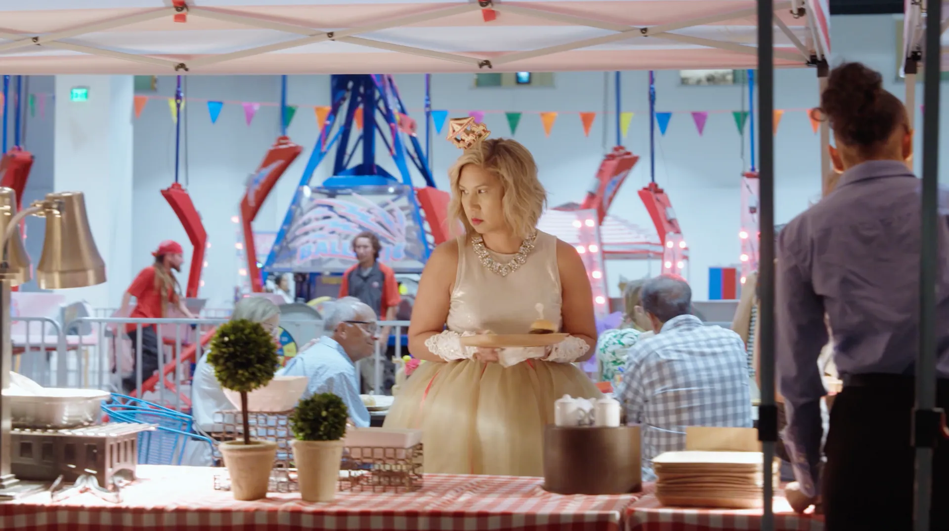 A woman in a dress is standing at a table at a carnival.