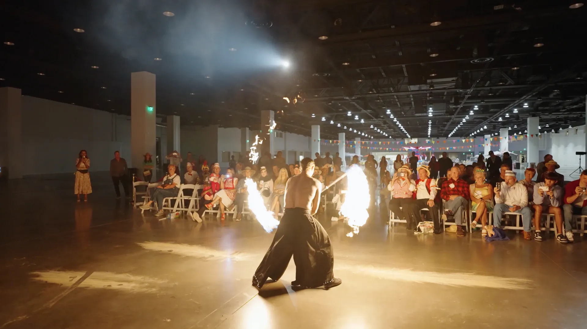 A man is dancing with fire in front of a crowd of people.
