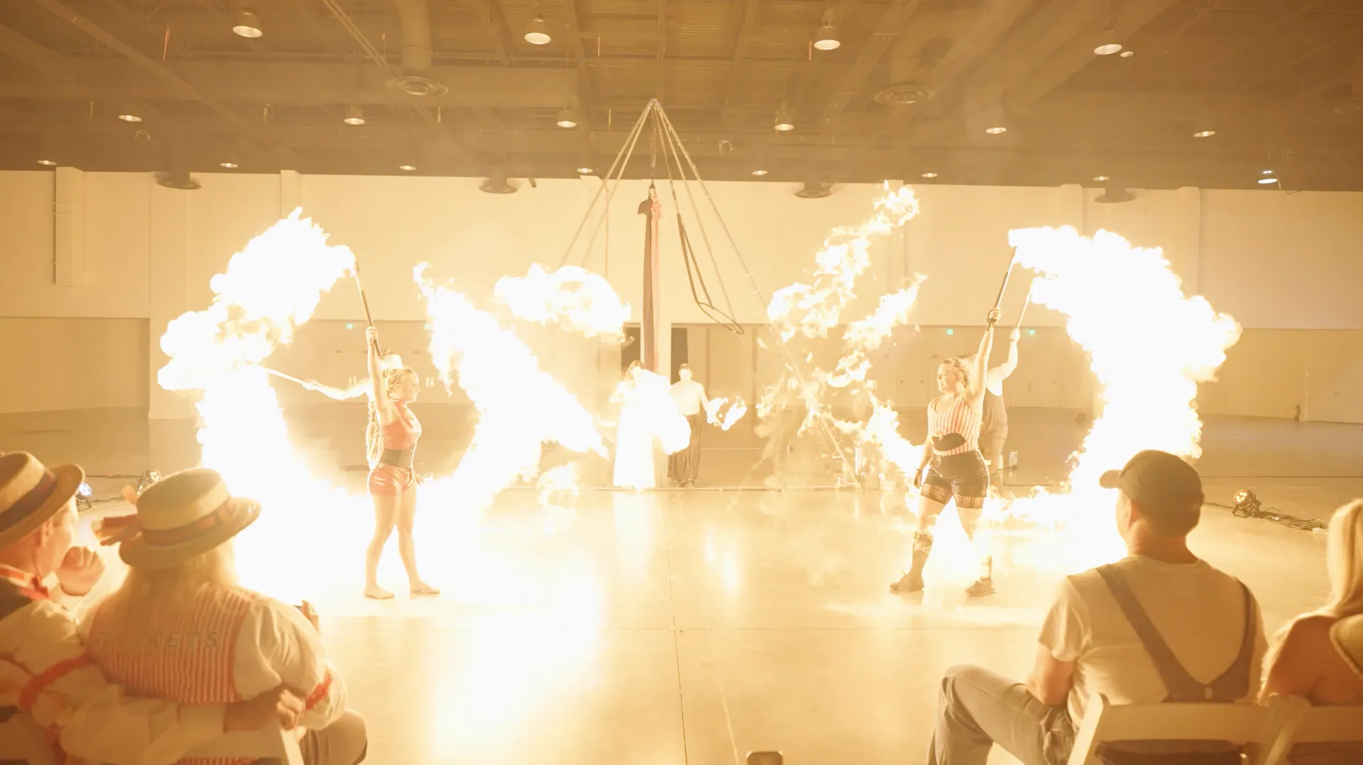 A group of people are sitting in chairs watching a fire show.