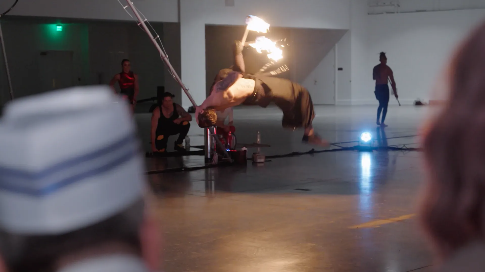 A group of people are watching a man do a trick with fire.