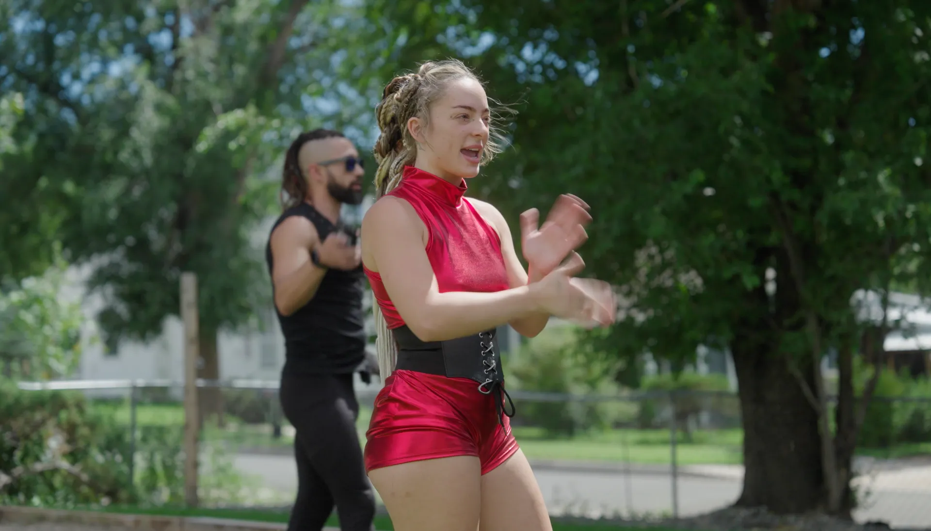 A man and a woman are dancing in a park.