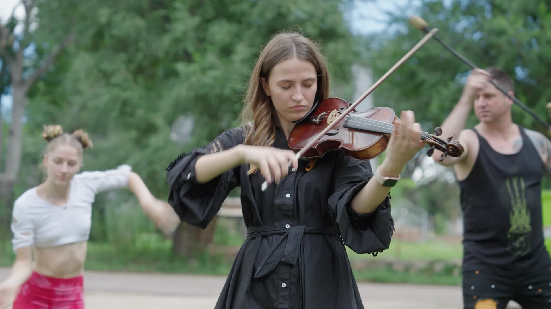 A woman is playing a violin in front of a group of people.