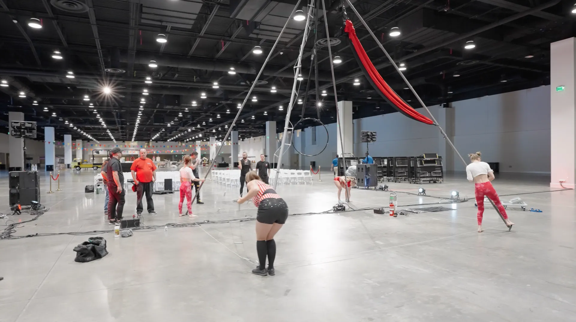 A group of people are standing in a large empty room.