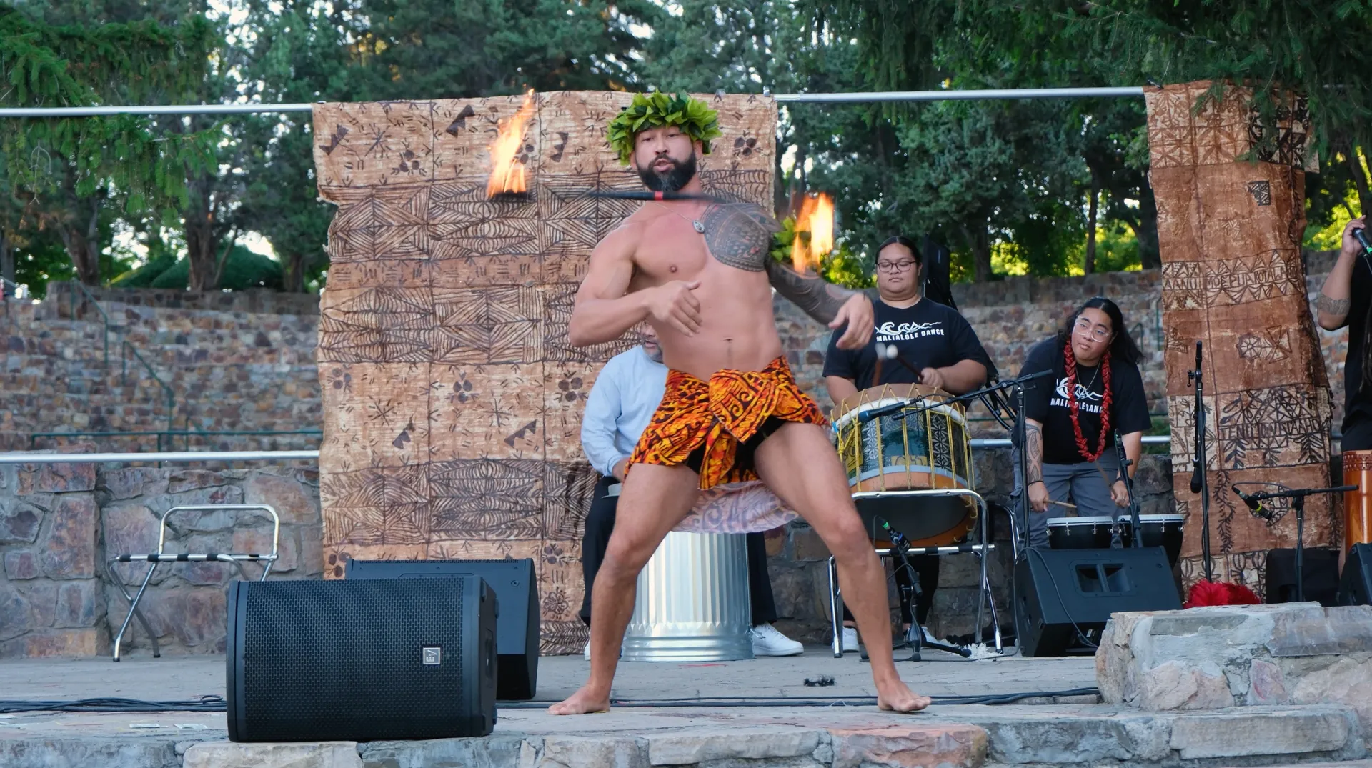 A man without a shirt is dancing on a stage