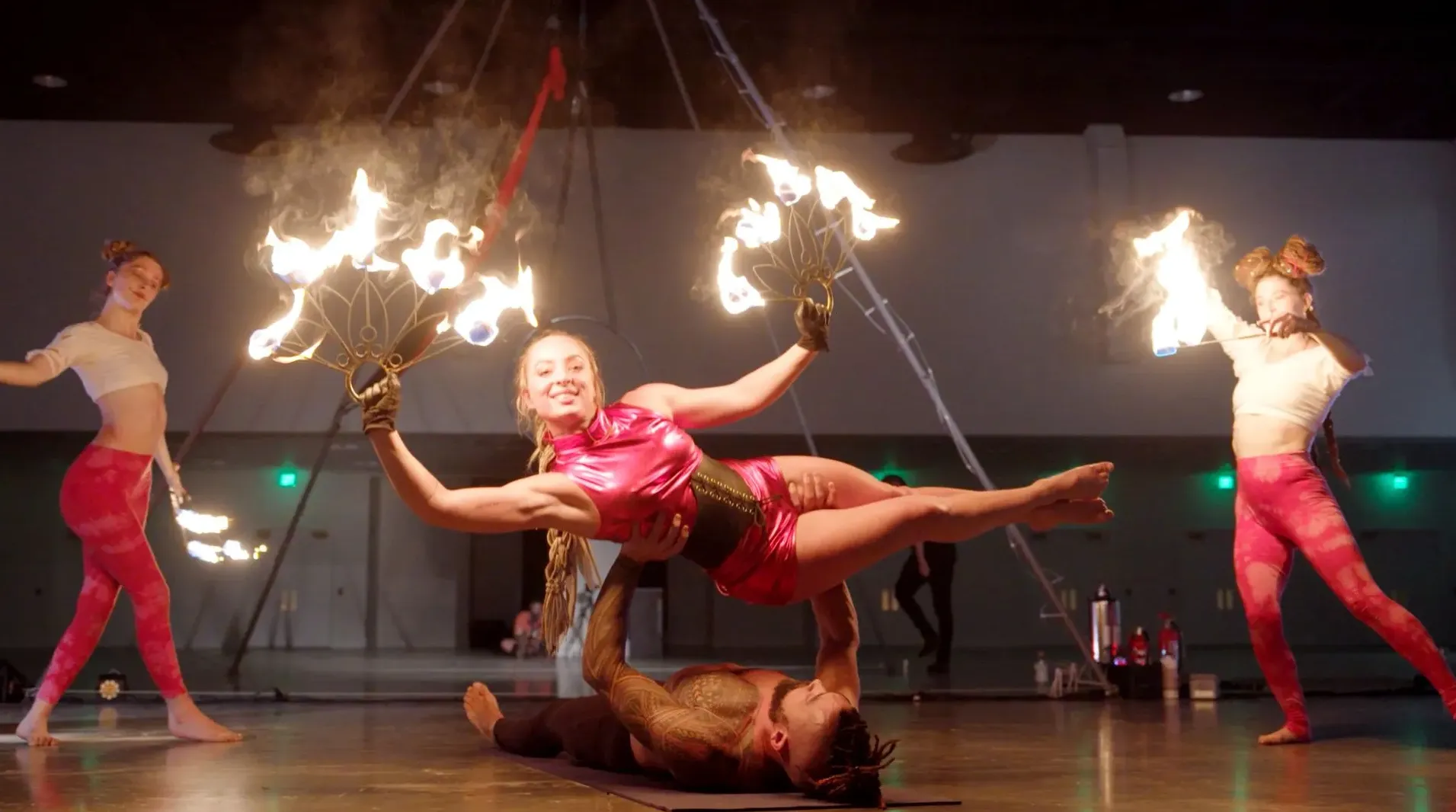 A group of people are performing aerial acrobatics with fire.
