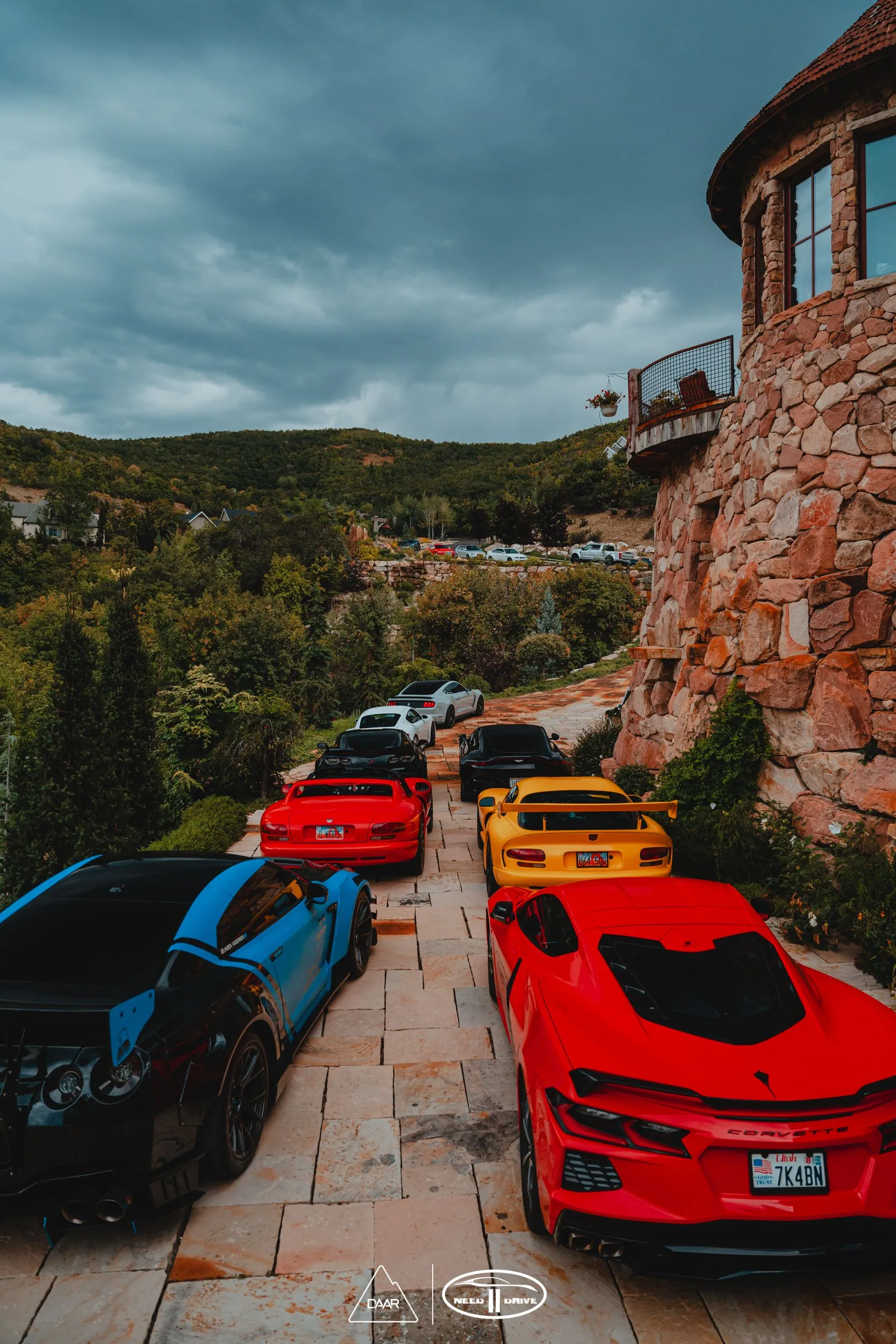 A row of sports cars parked in front of a stone building.