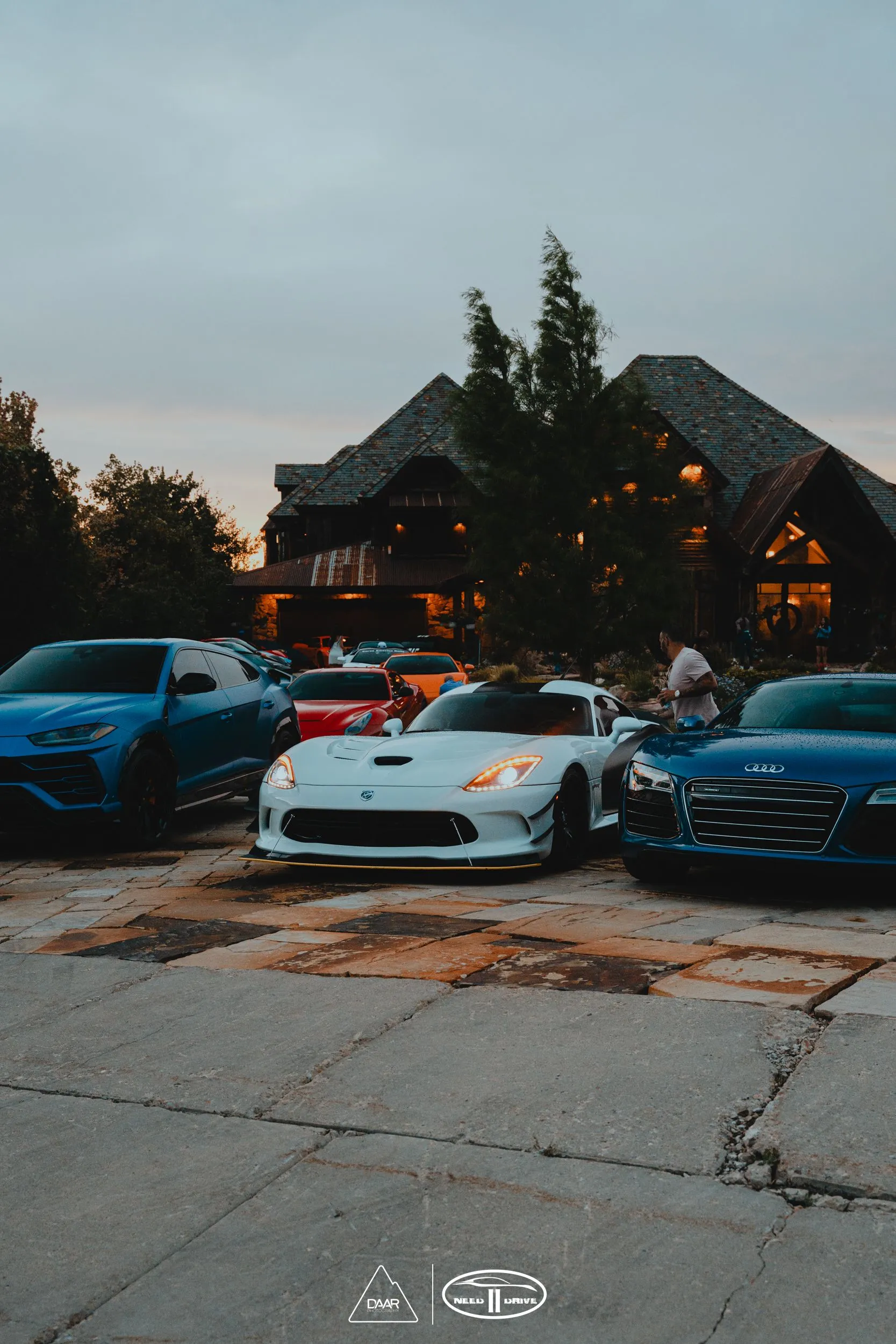 A group of cars are parked in front of a house.