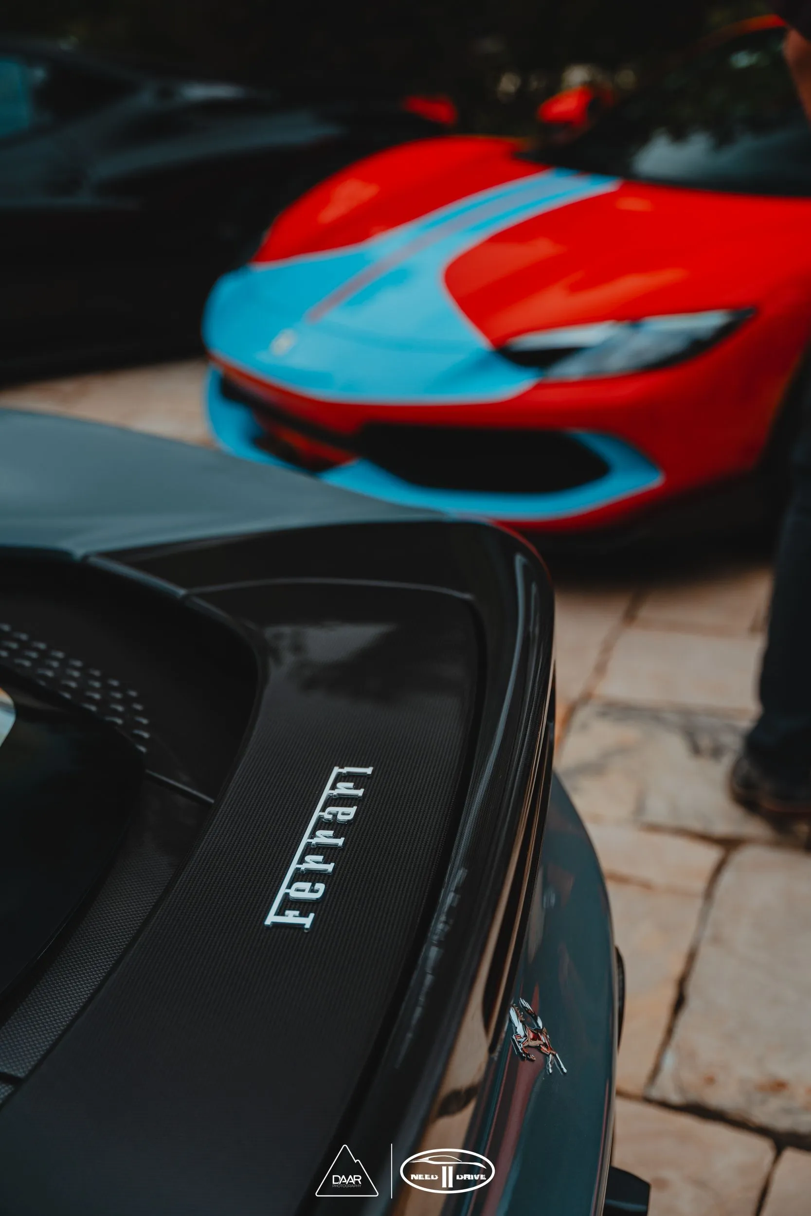 A ferrari car is parked next to a blue car.