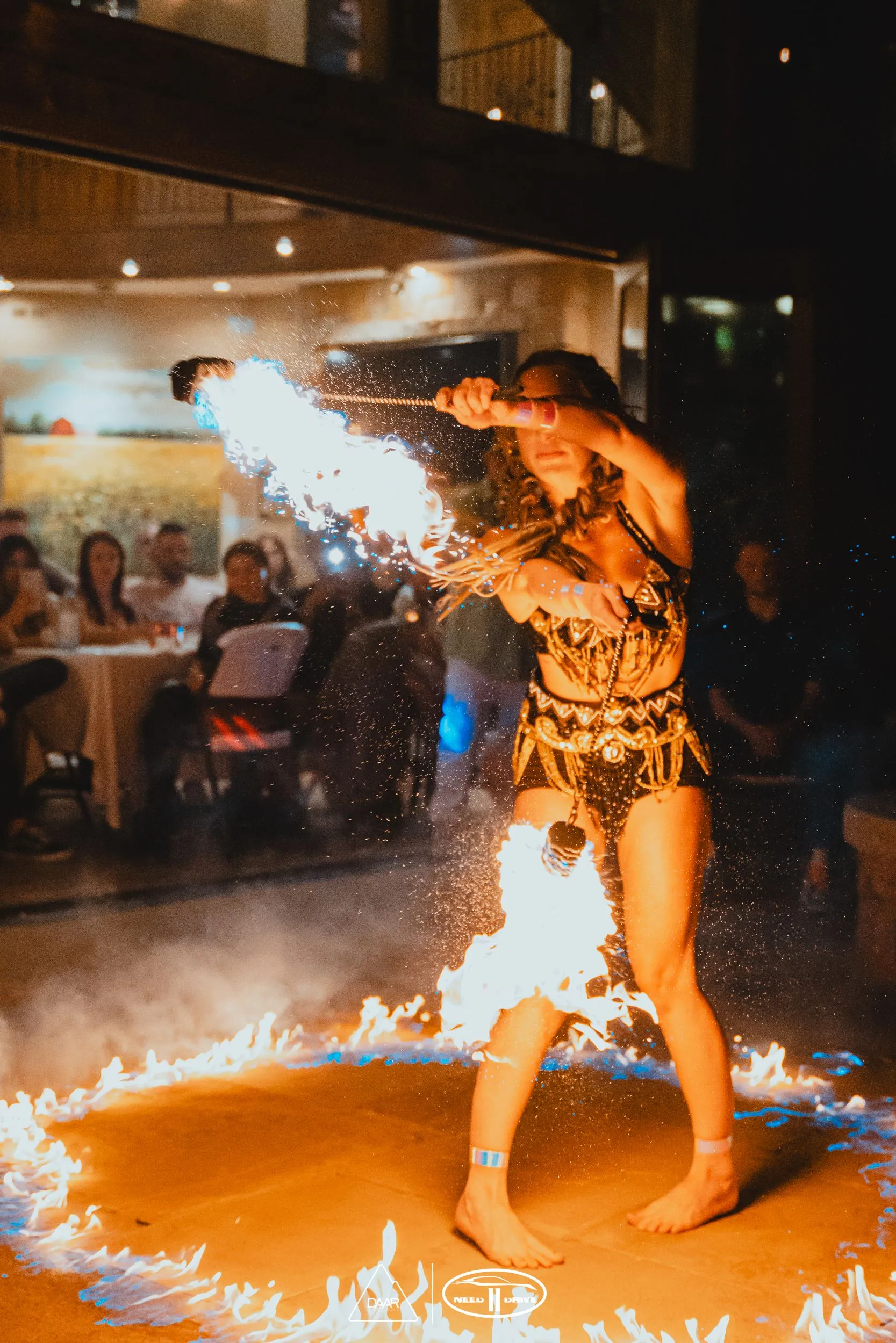 A woman is standing in a circle of fire.