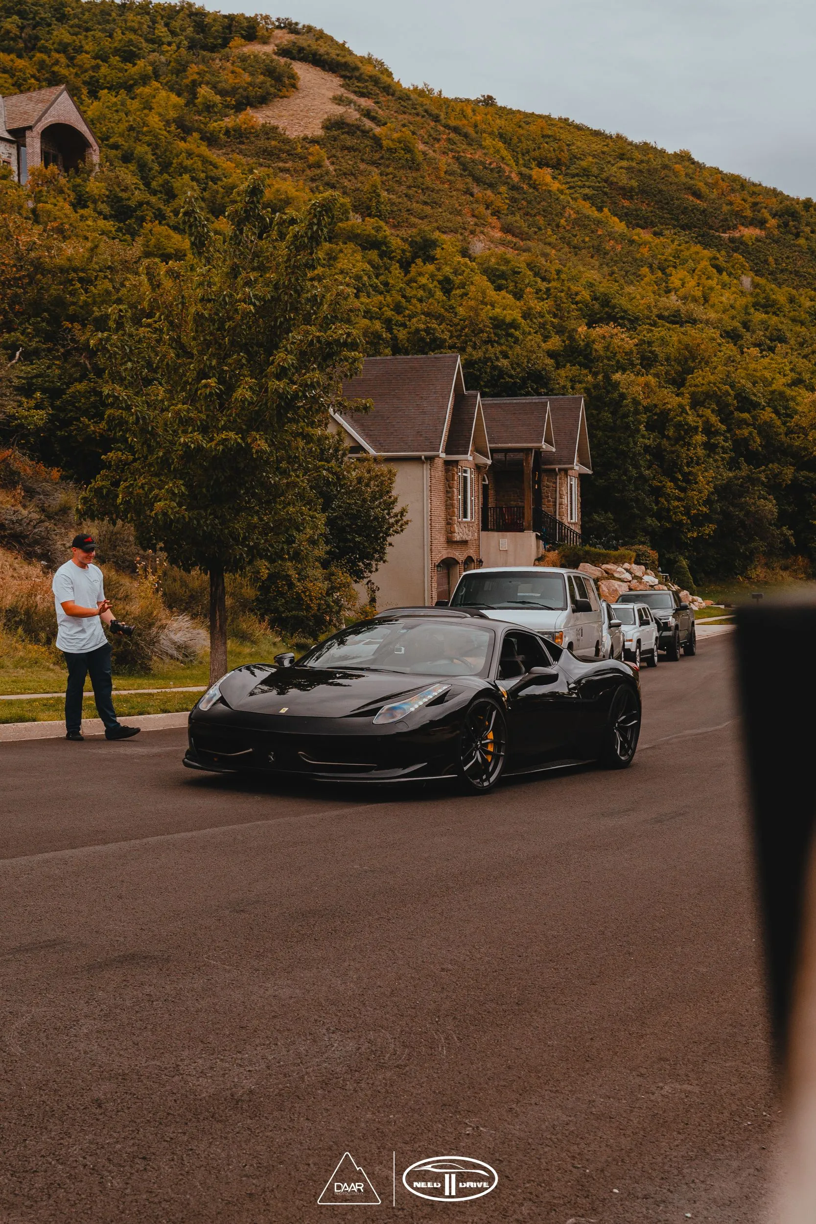A row of black sports cars are parked on the side of the road.