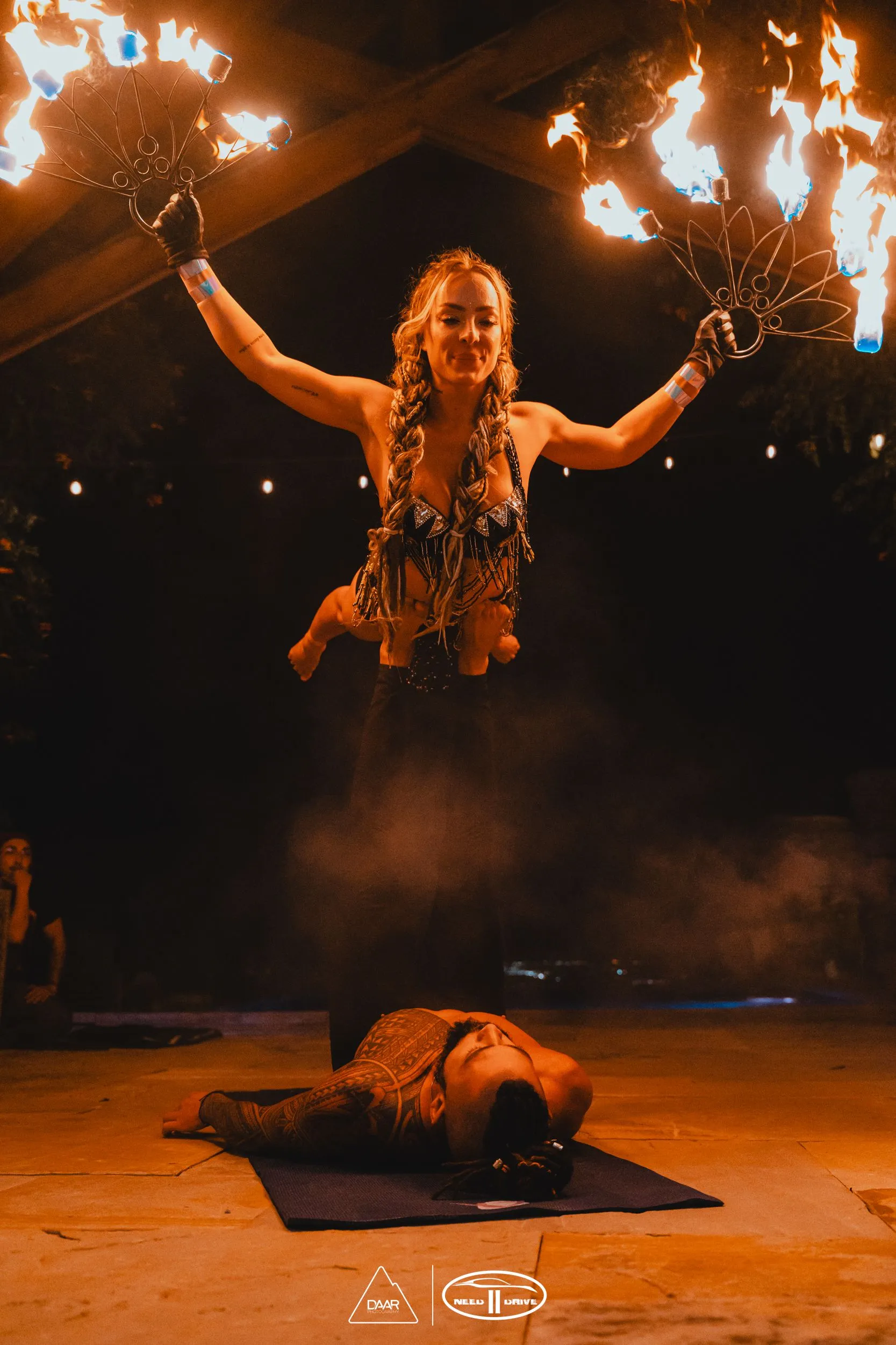 A man and woman performing acrobatic fire.
