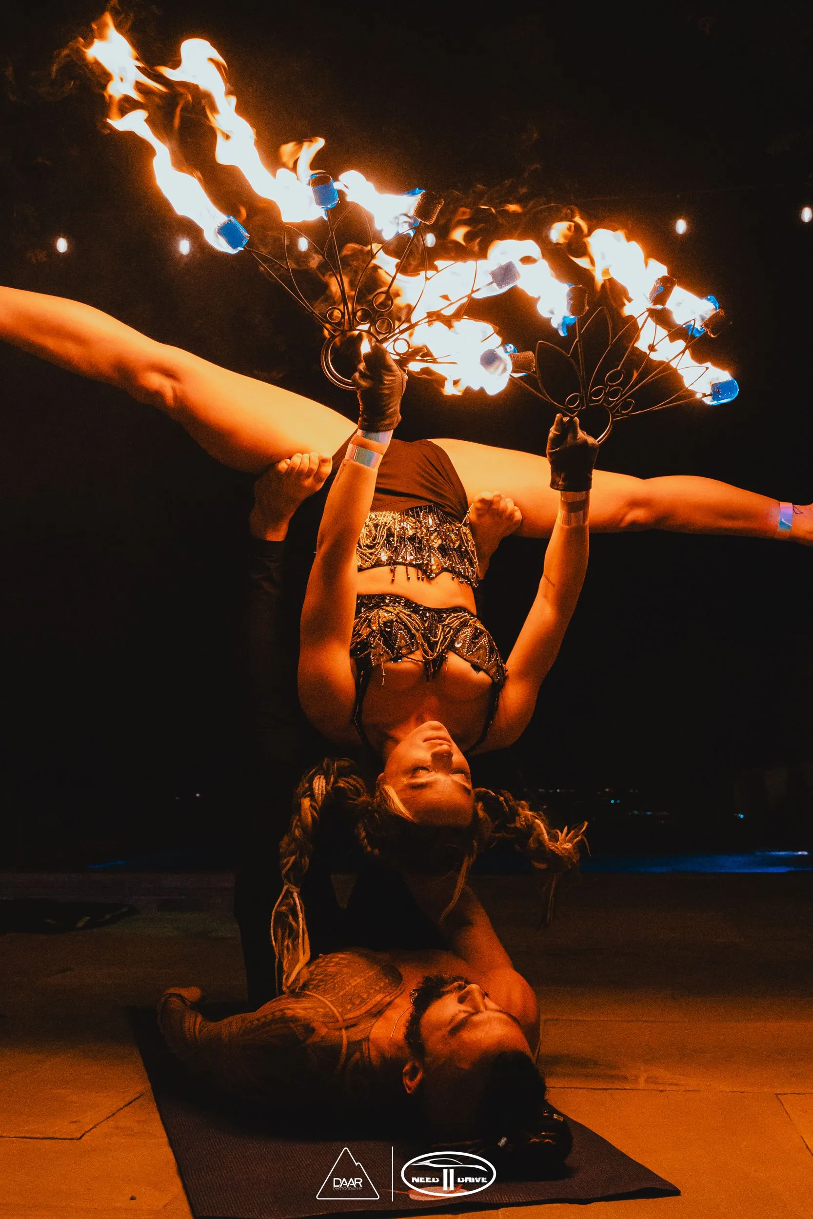 A man and woman performing acrobatic fire.