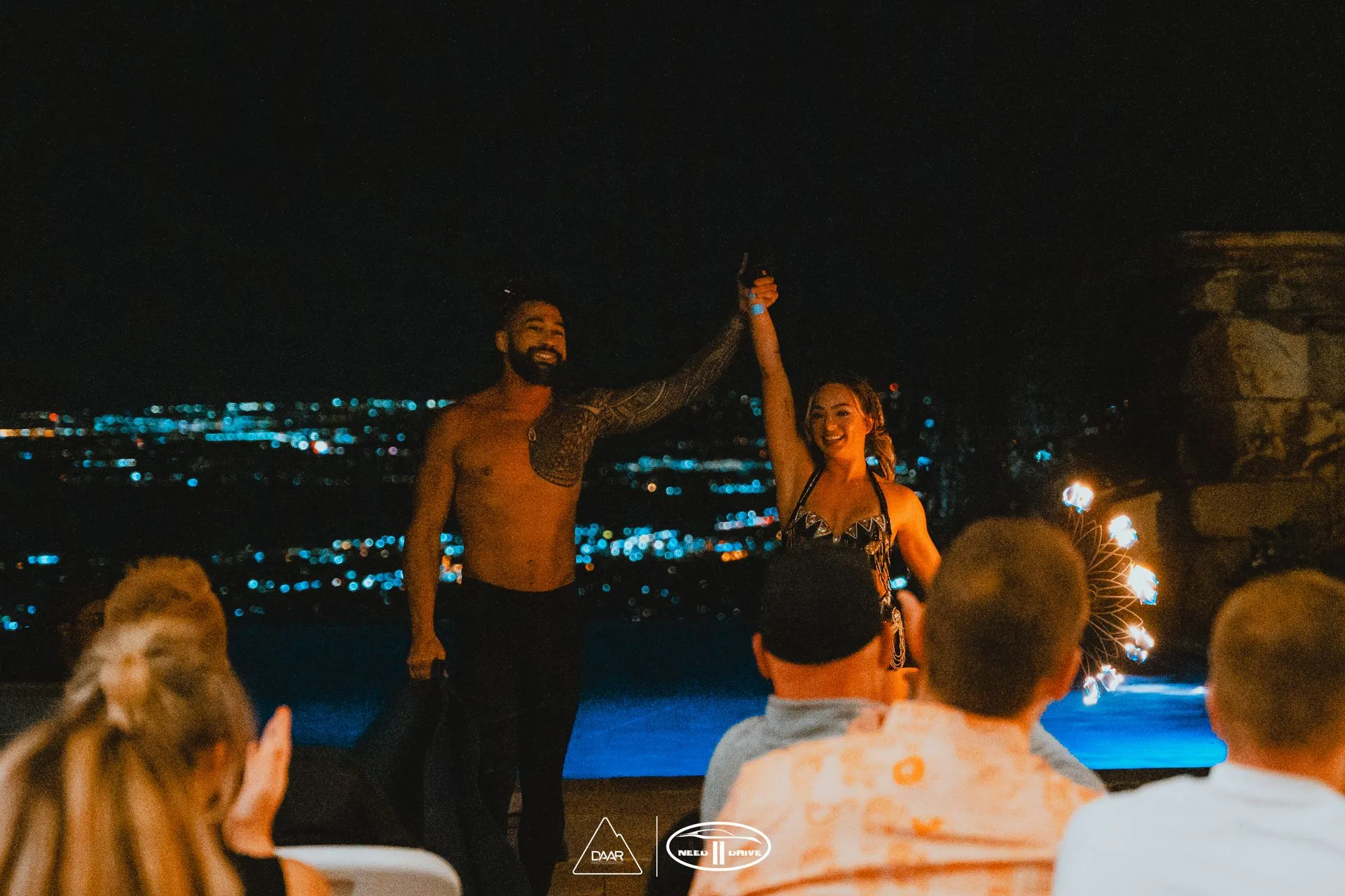 A man and a woman are holding hands in front of a crowd of people.