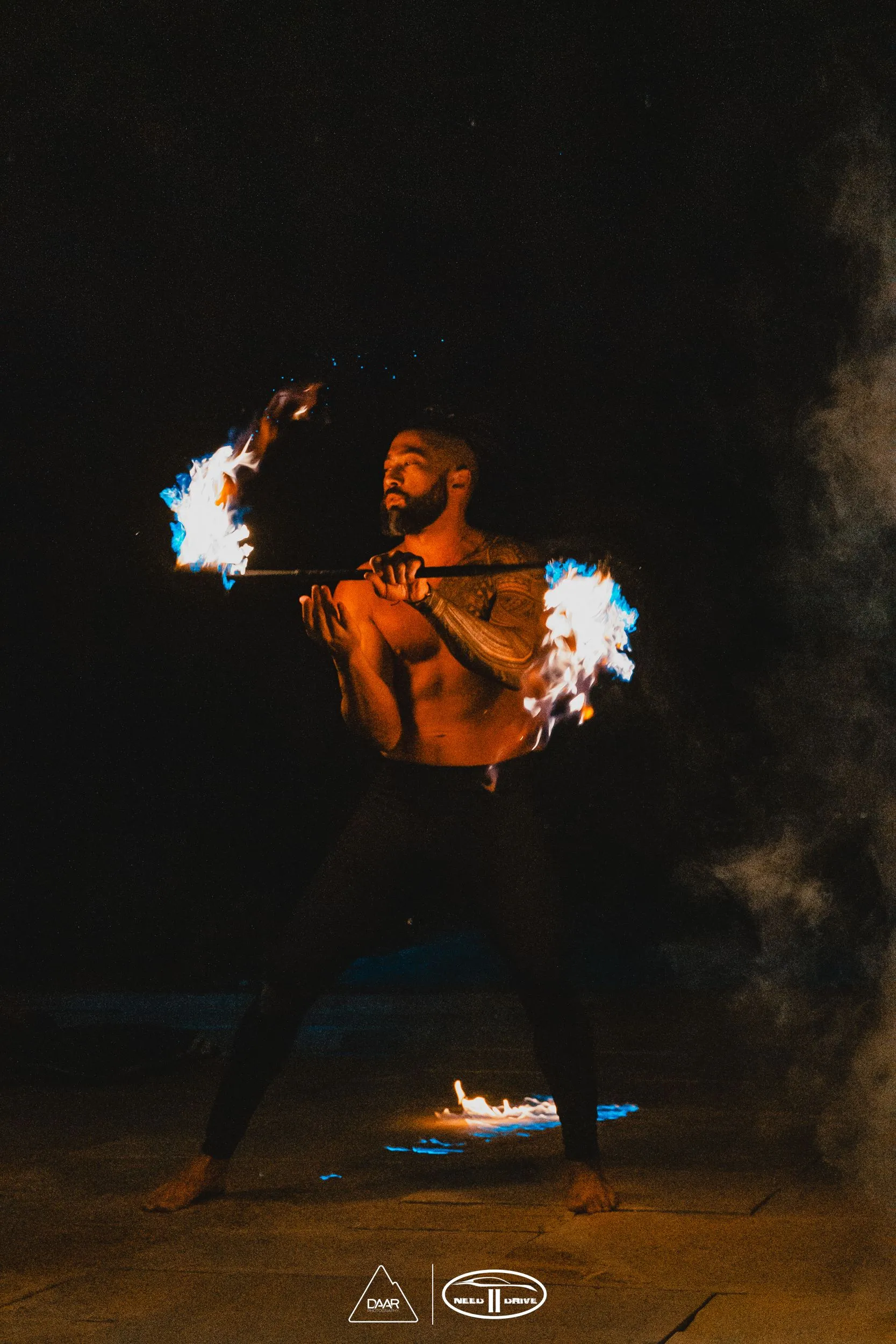 A man without a shirt is holding a fireball in his hands.