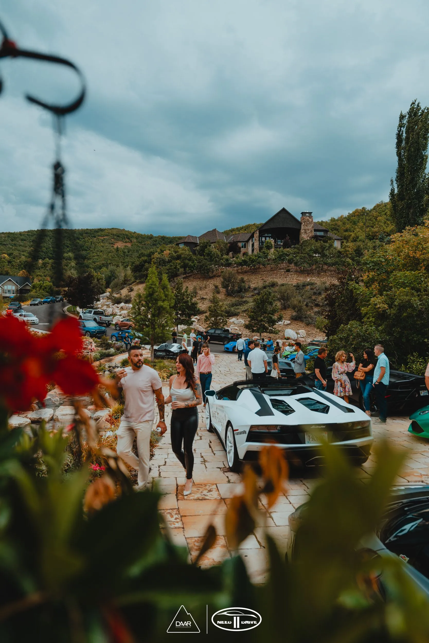 A group of people are walking in front of a car parked in a parking lot.