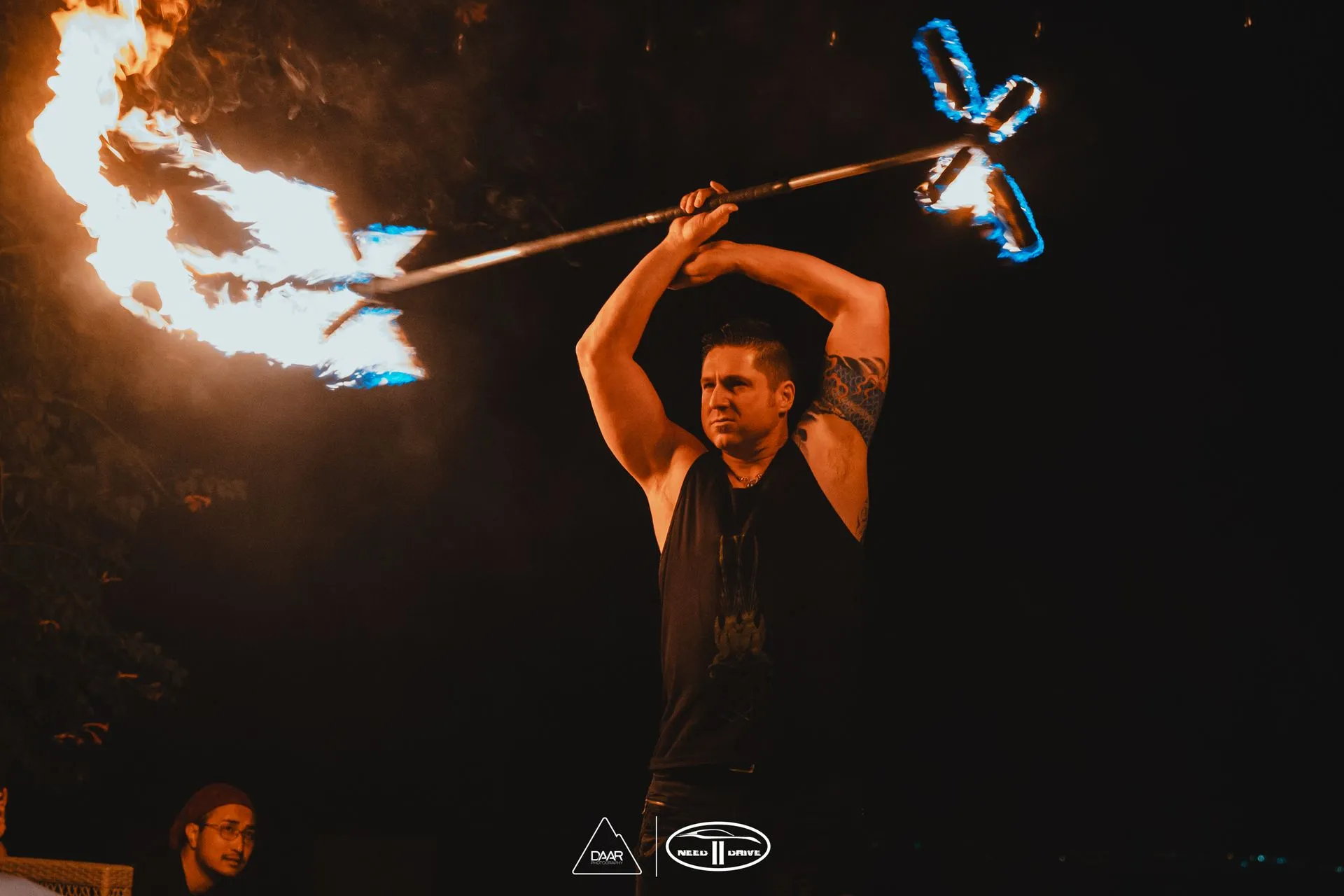 A man is holding a fire stick in the dark.