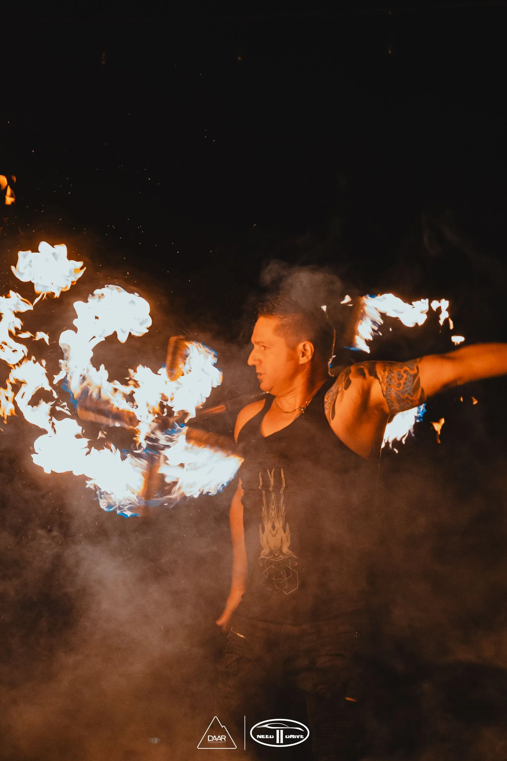 A man is holding a torch with flames coming out of it.