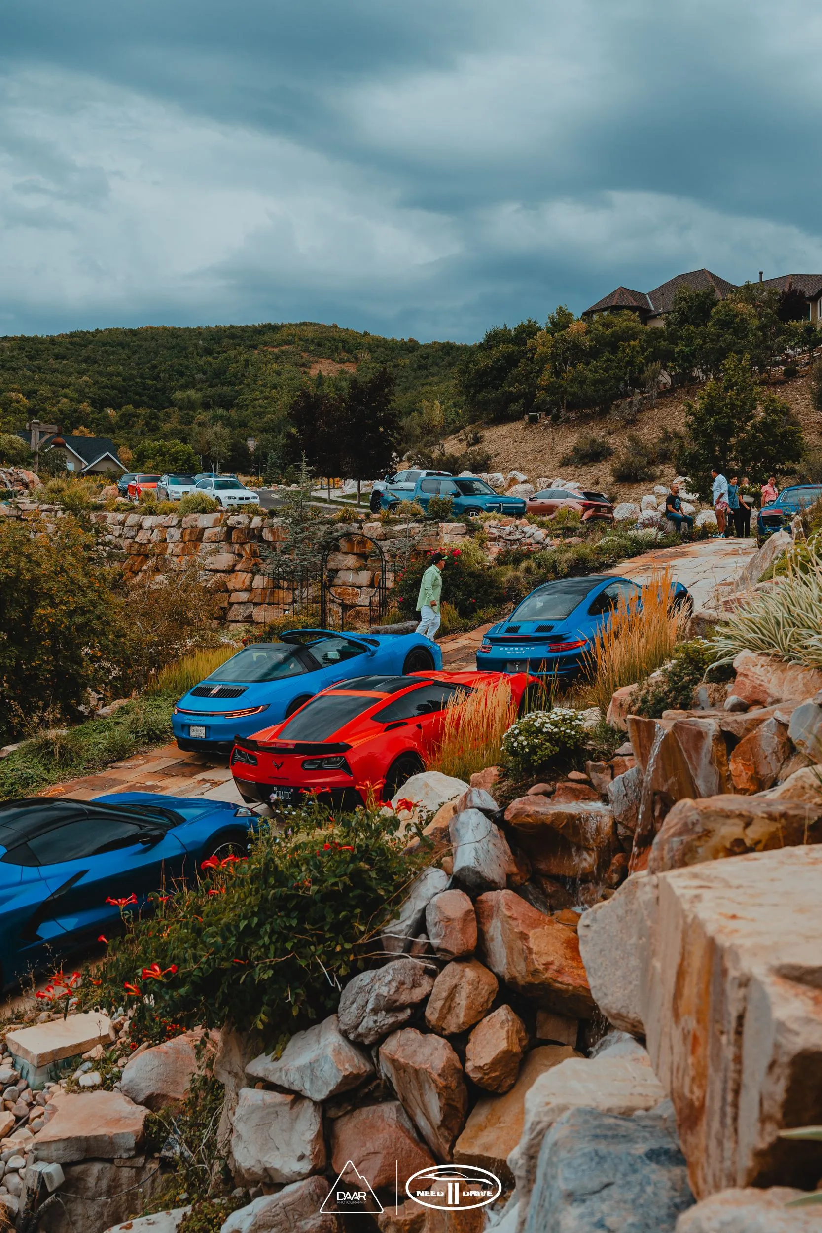 A group of cars are parked on top of a rocky hillside.