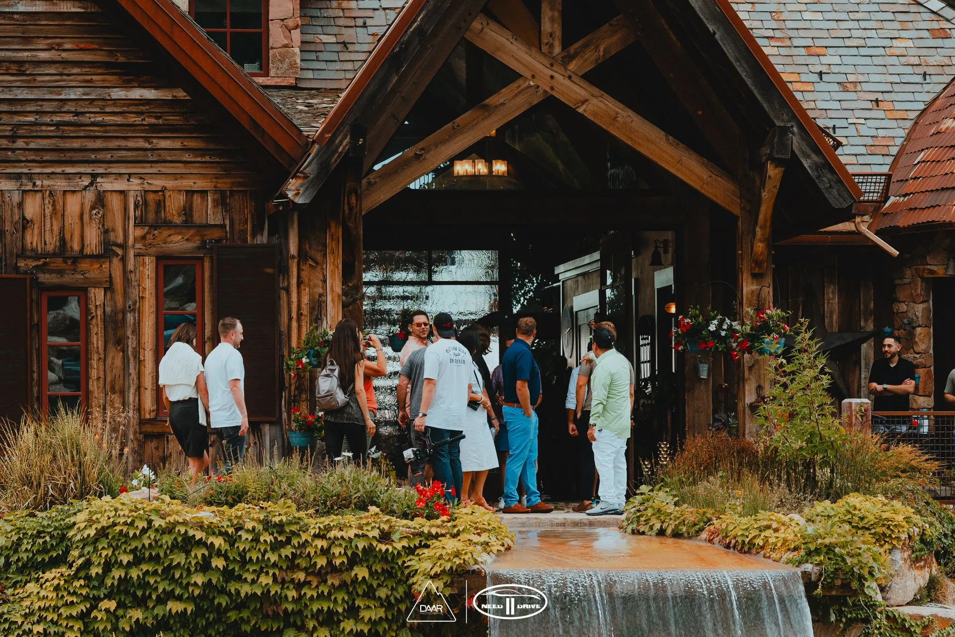 A group of people are standing in front of a wooden house.