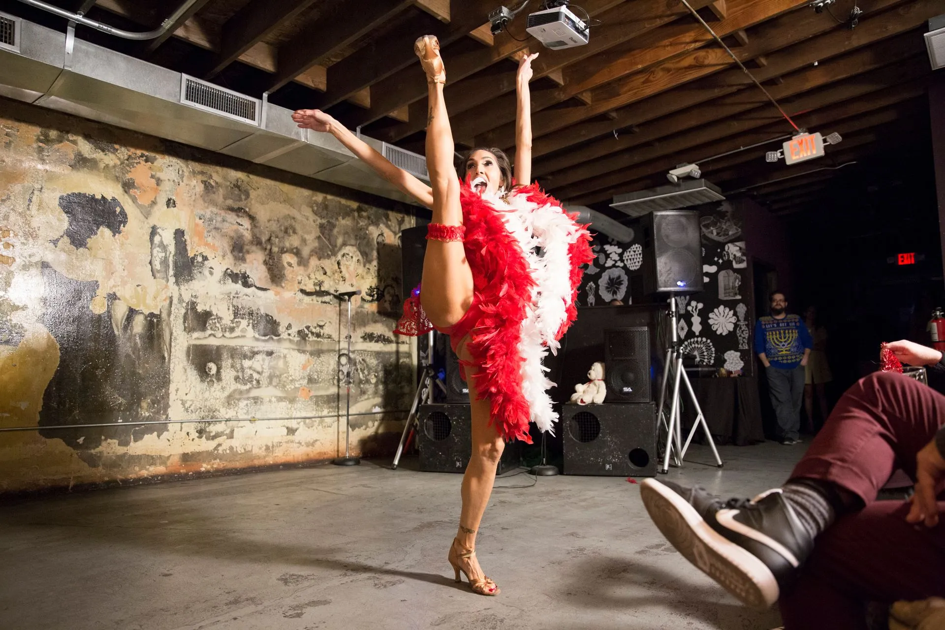 A woman in a red and white dress is doing a split on a stage.