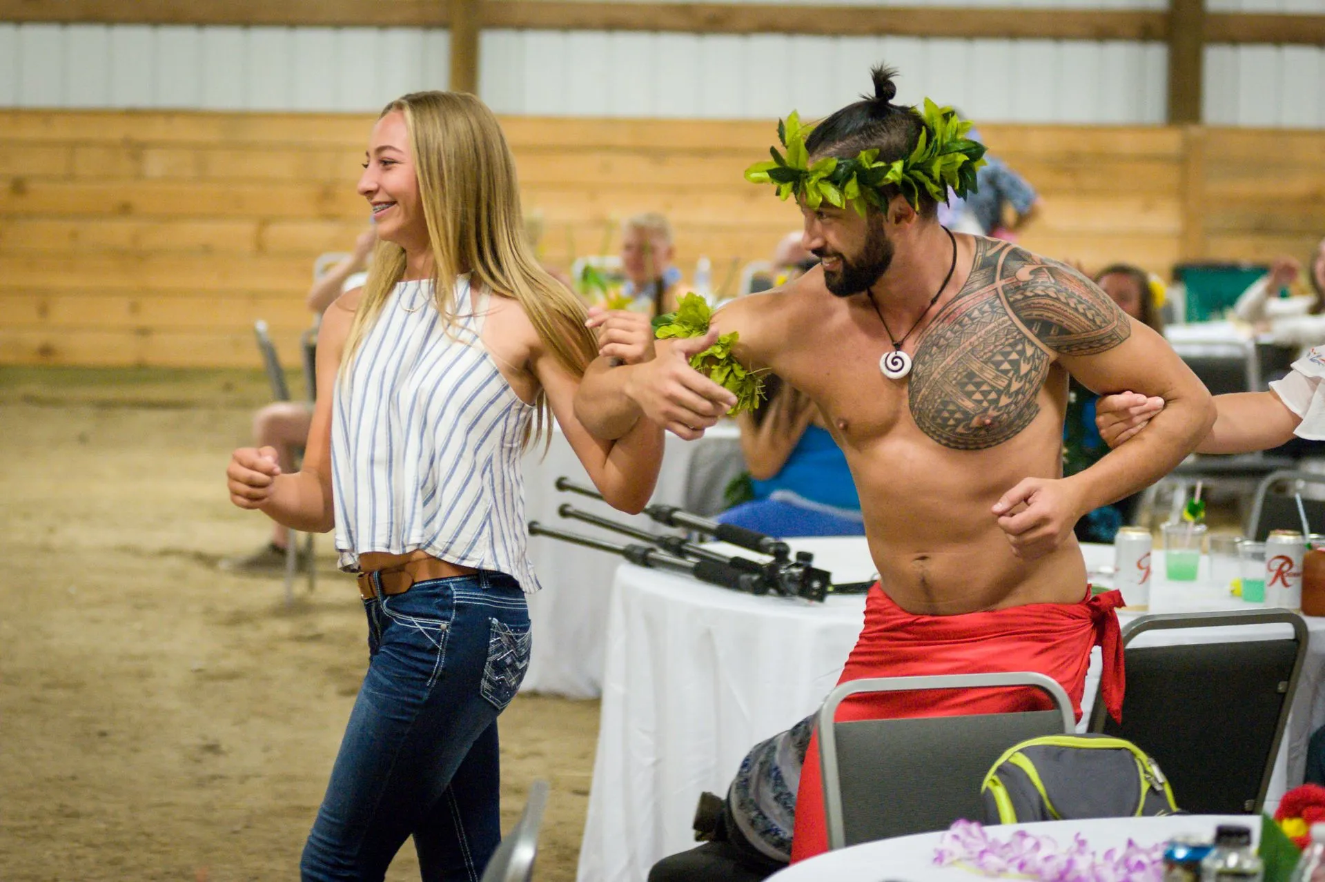 A man without a shirt is dancing with a woman.