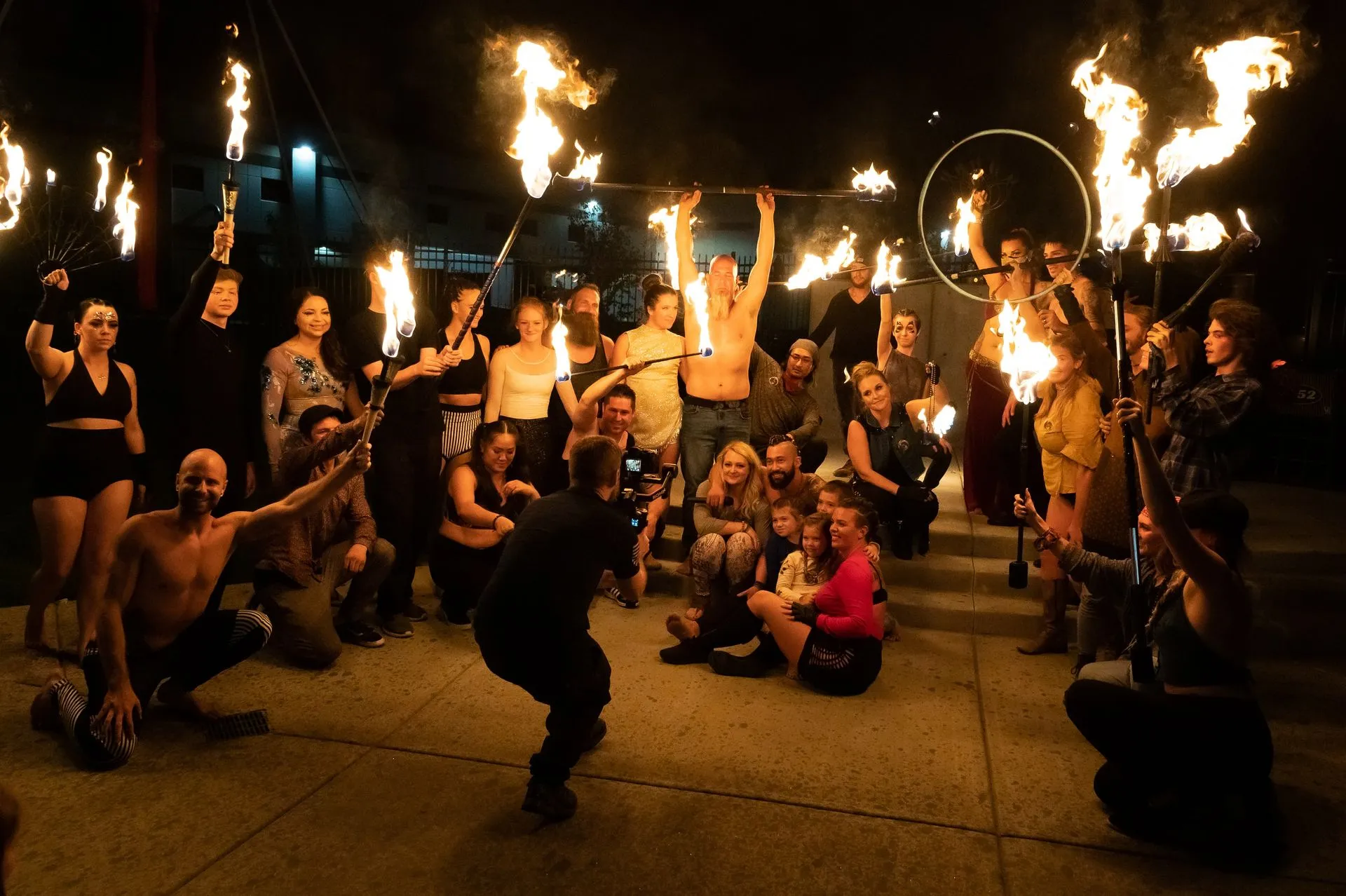 A group of people are posing for a picture with fire in their hands.