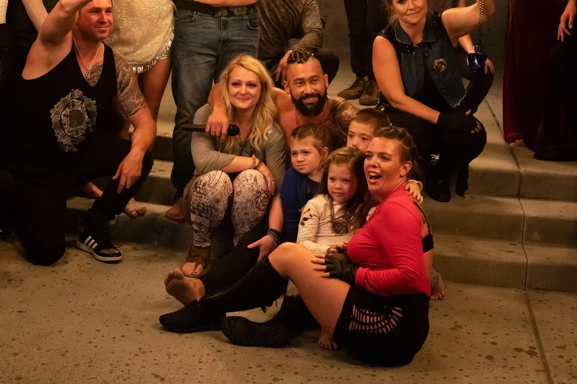 A group of people are posing for a picture on the sidewalk.