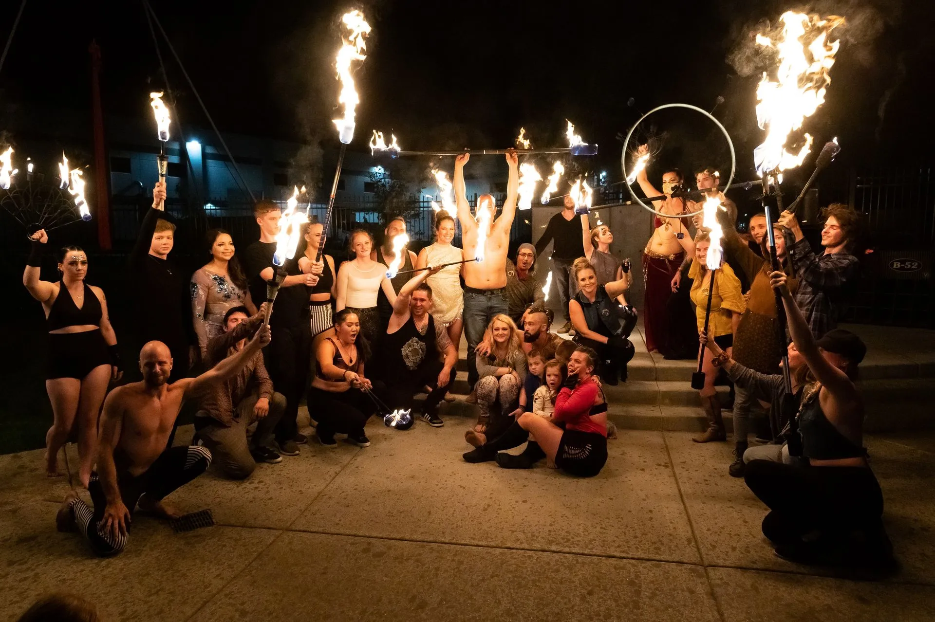 A group of people are posing for a picture while holding fire torches.