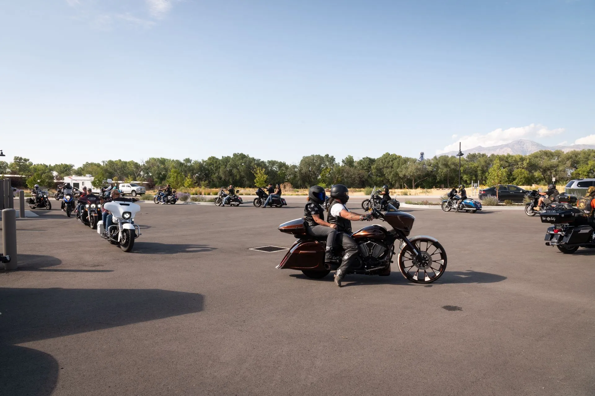 A group of people riding motorcycles in a parking lot