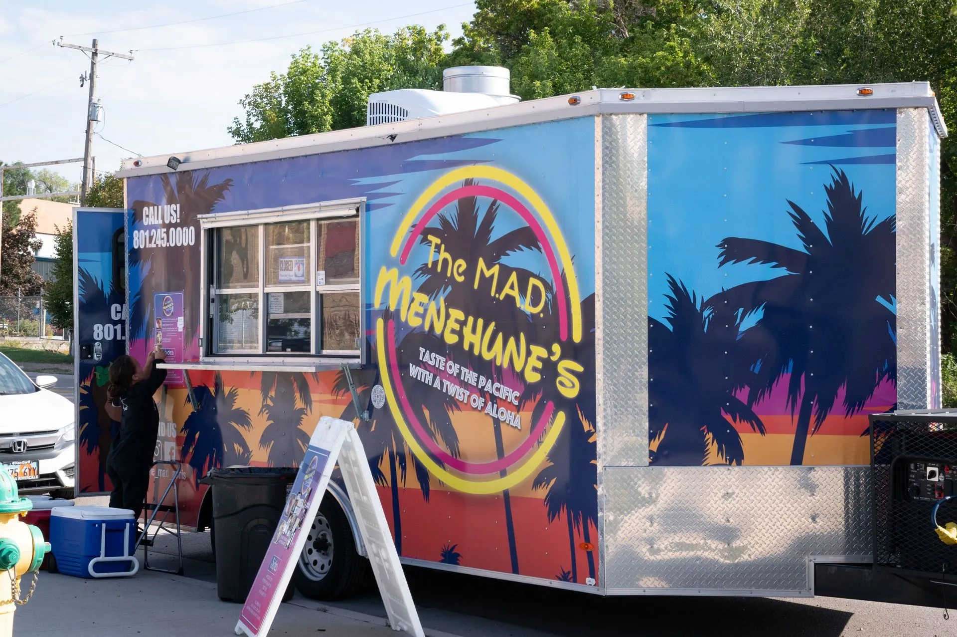 A food truck that says the mad menehune 's on it