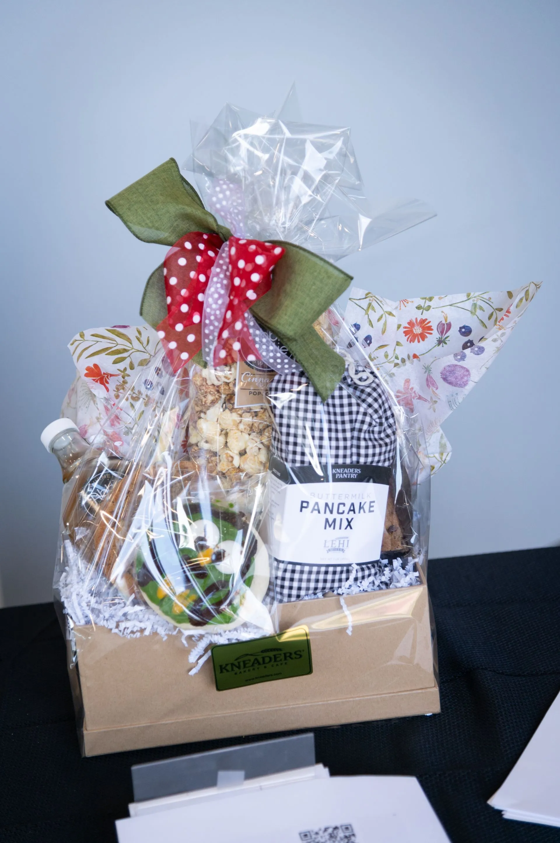 A gift basket with a bow is sitting on a table.