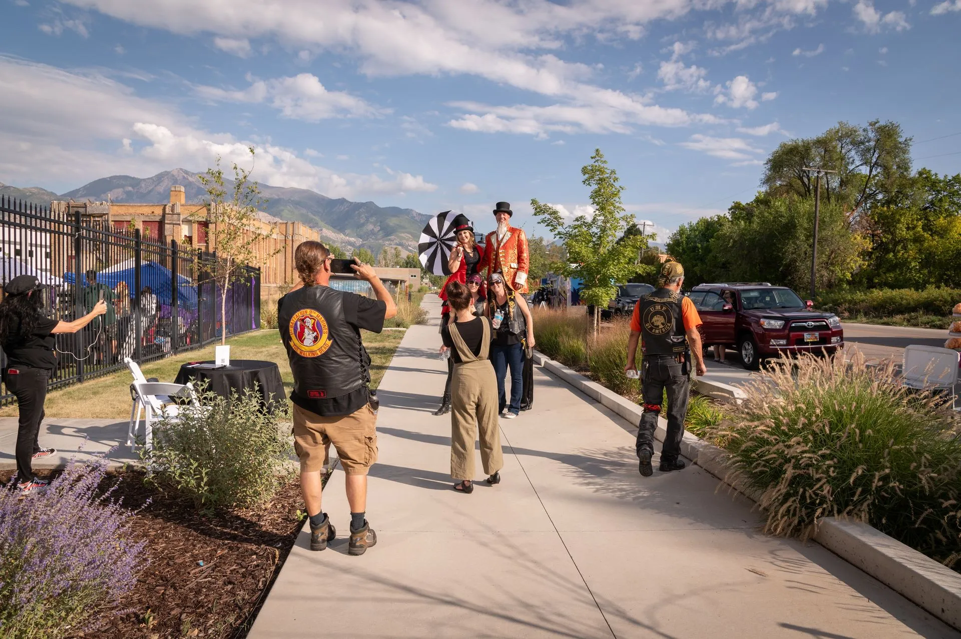 A group of people are standing on a sidewalk.