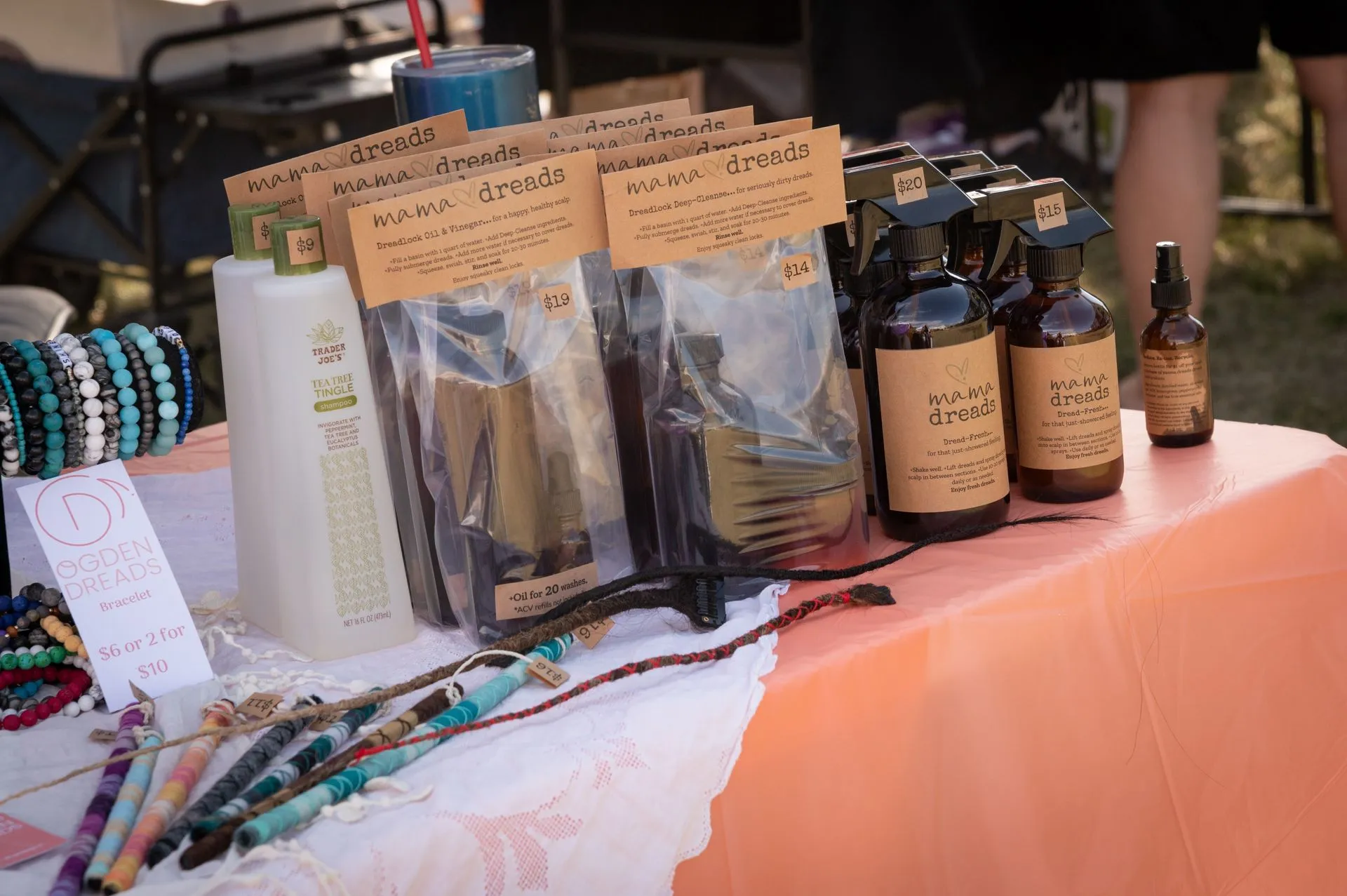 A table with bottles , bags , and bracelets on it.