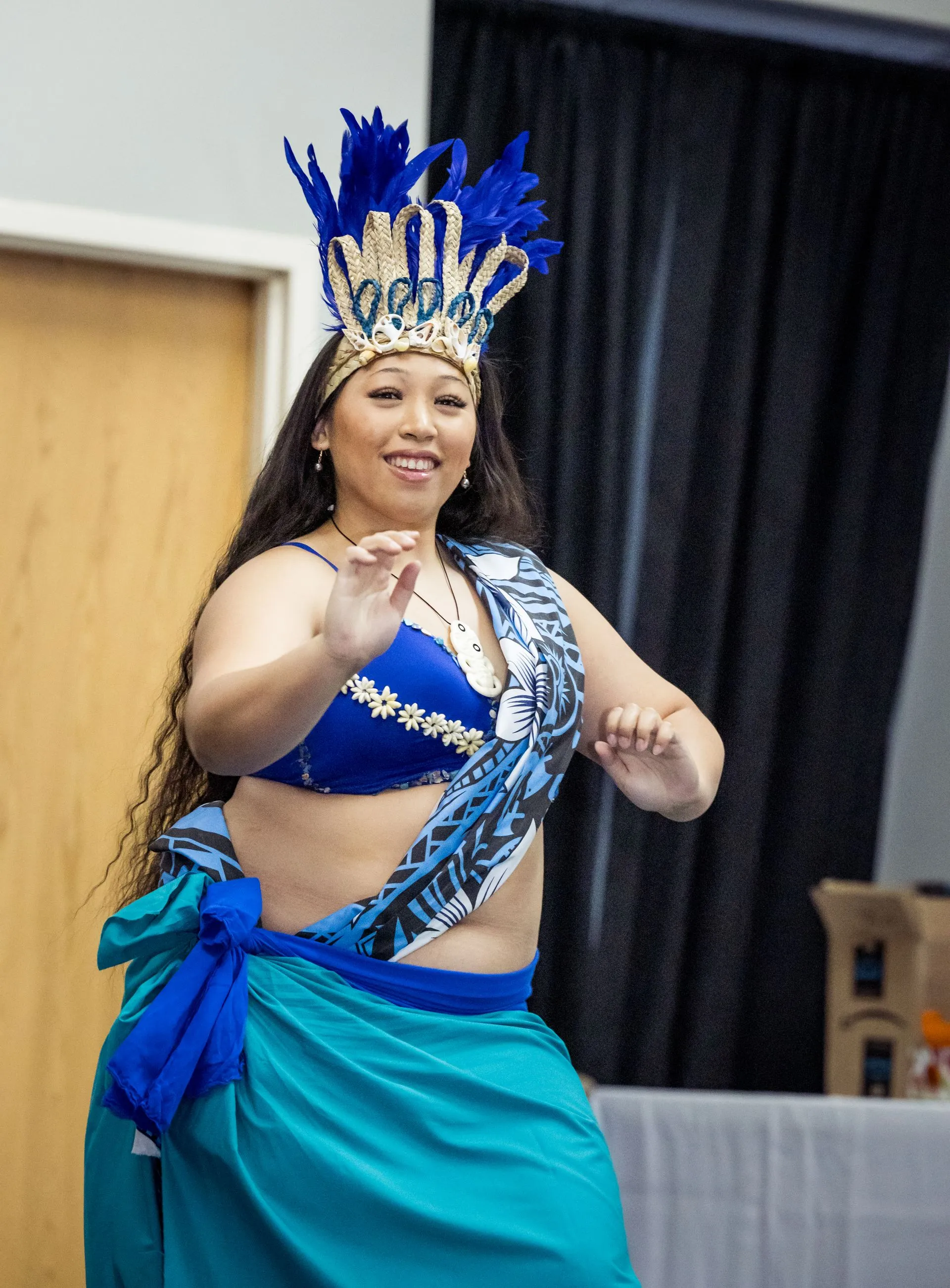 A woman in a blue top and blue skirt is dancing.