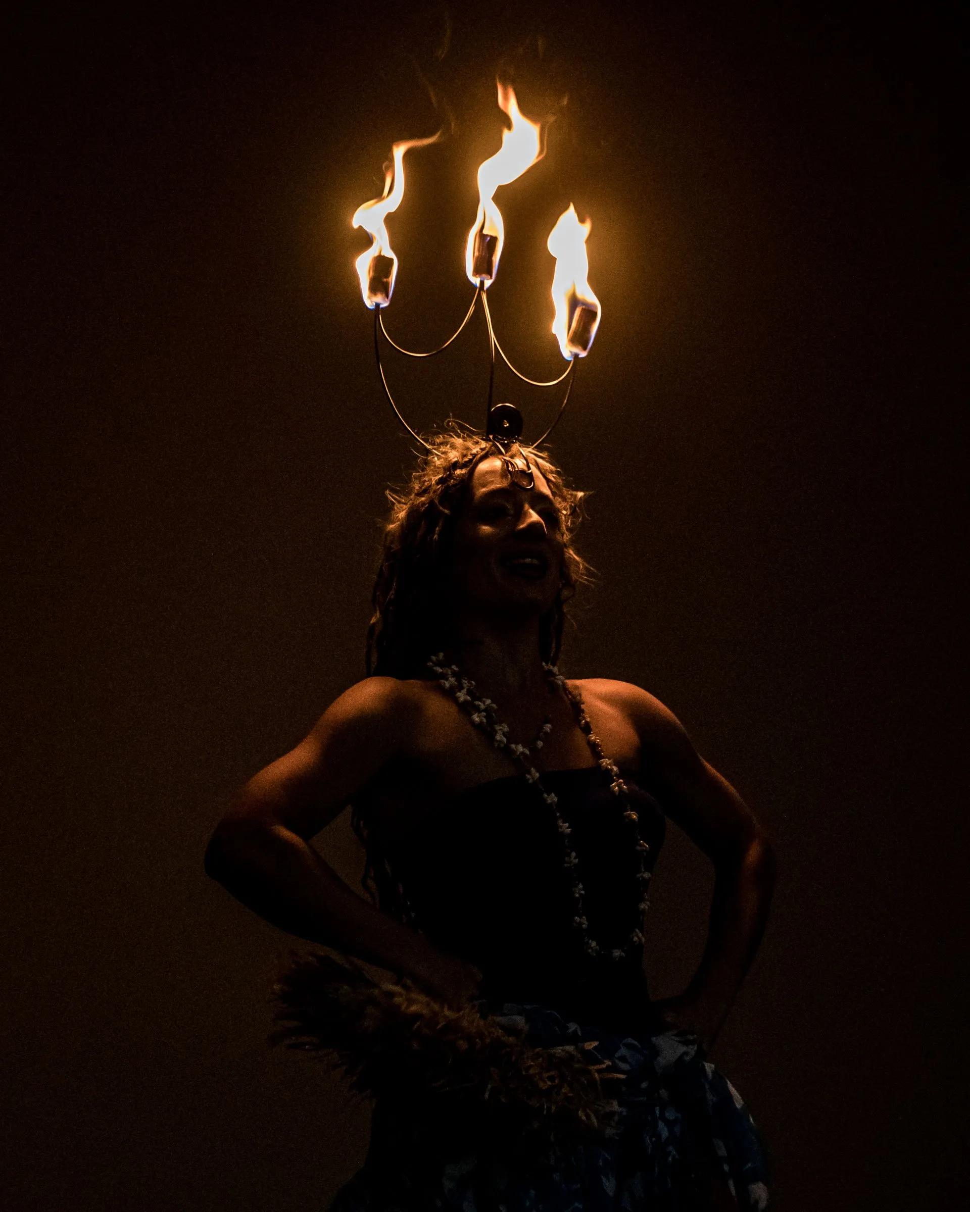 A woman is wearing a crown of flames on her head.