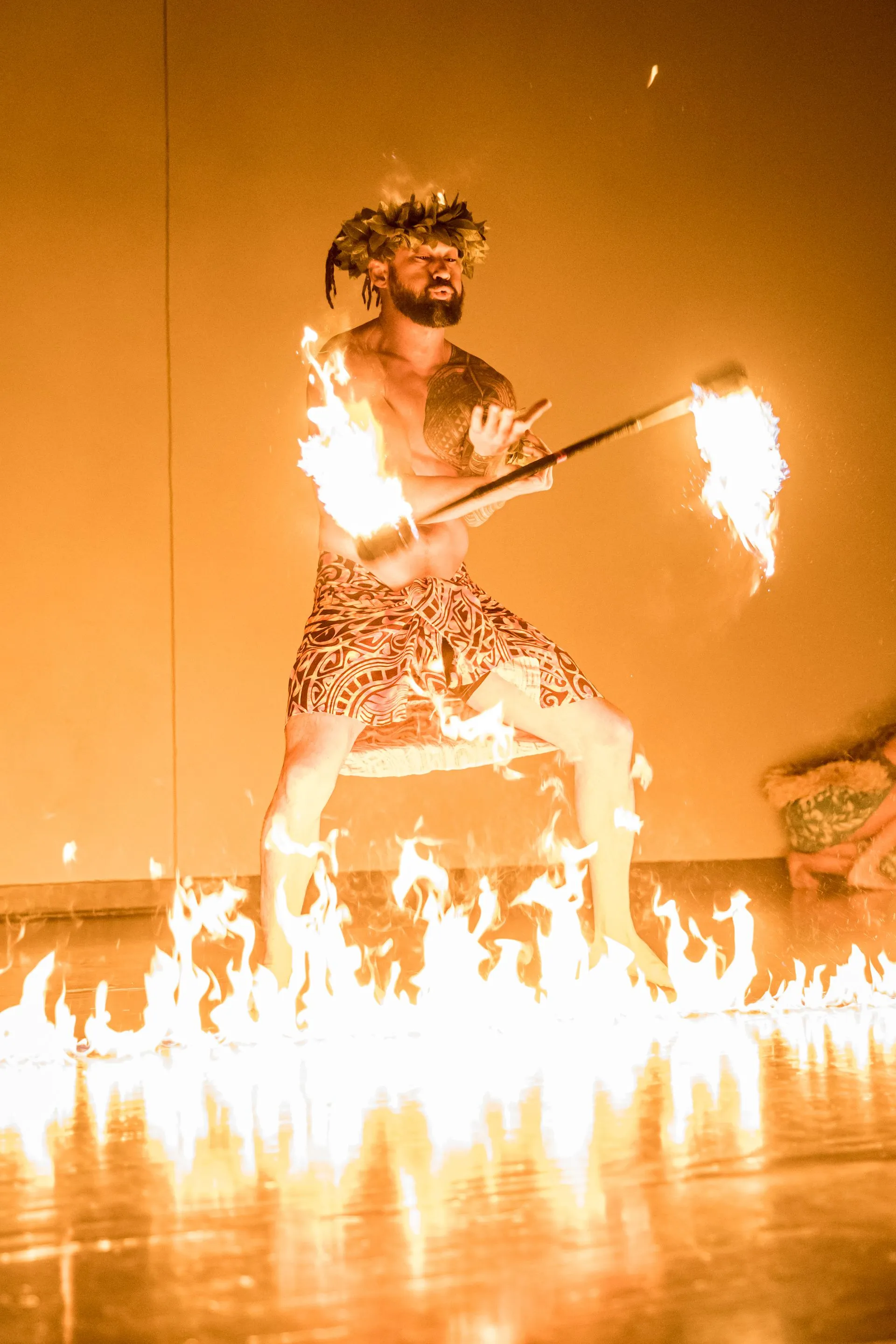 A man is holding a stick with flames coming out of it.