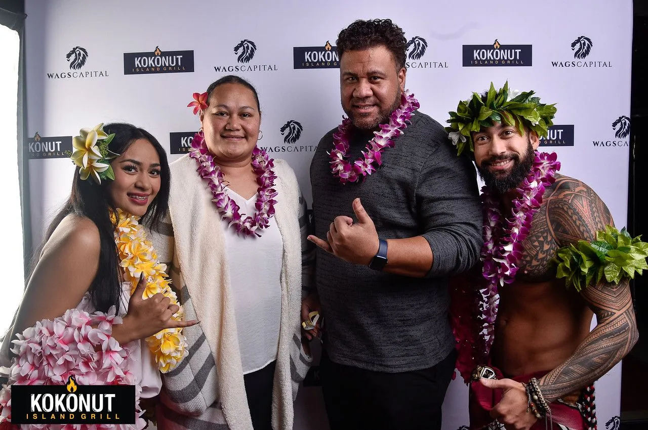 A group of people wearing lei are posing for a picture.